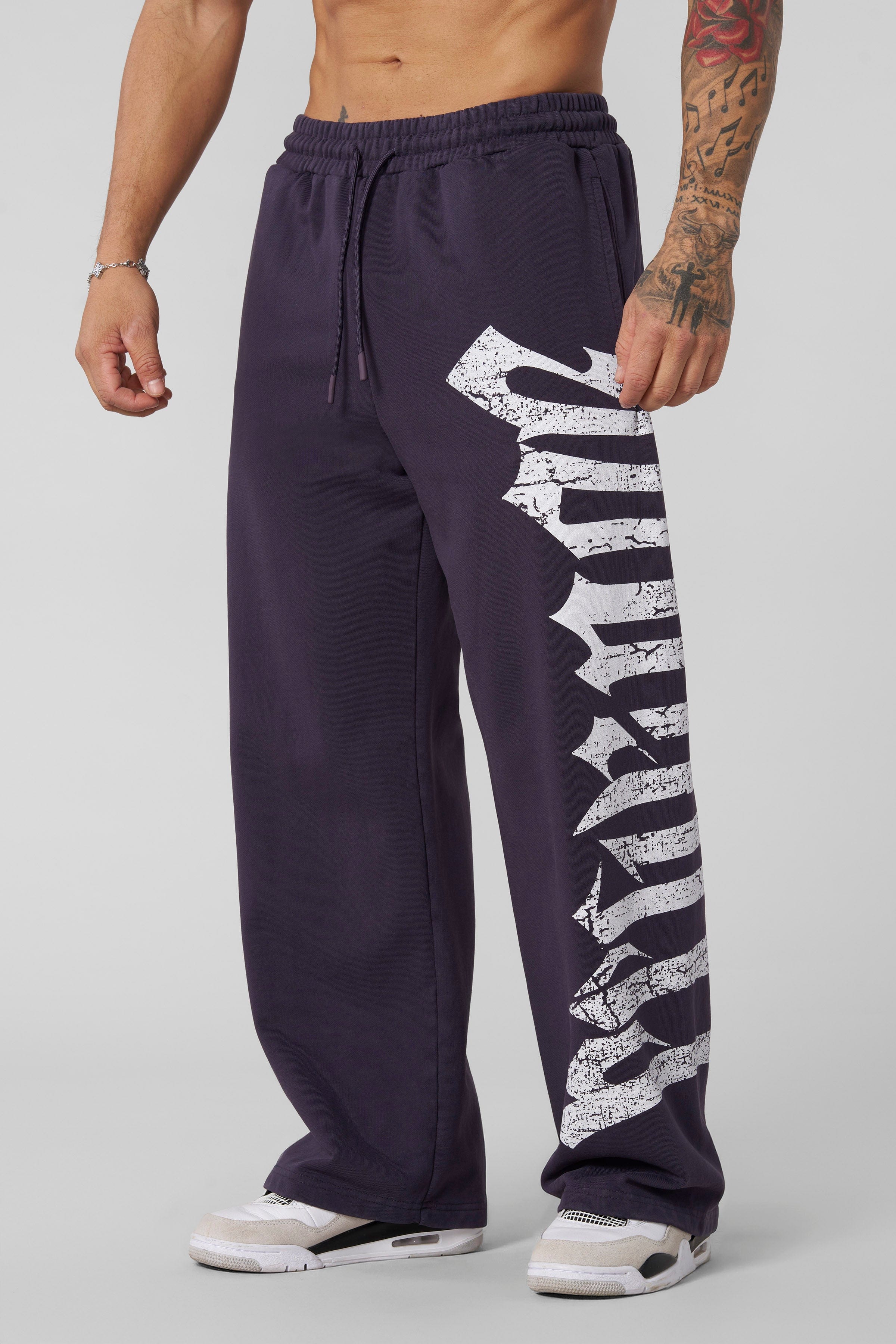Full-body shot of model wearing black joggers styled with hoodie in urban setting