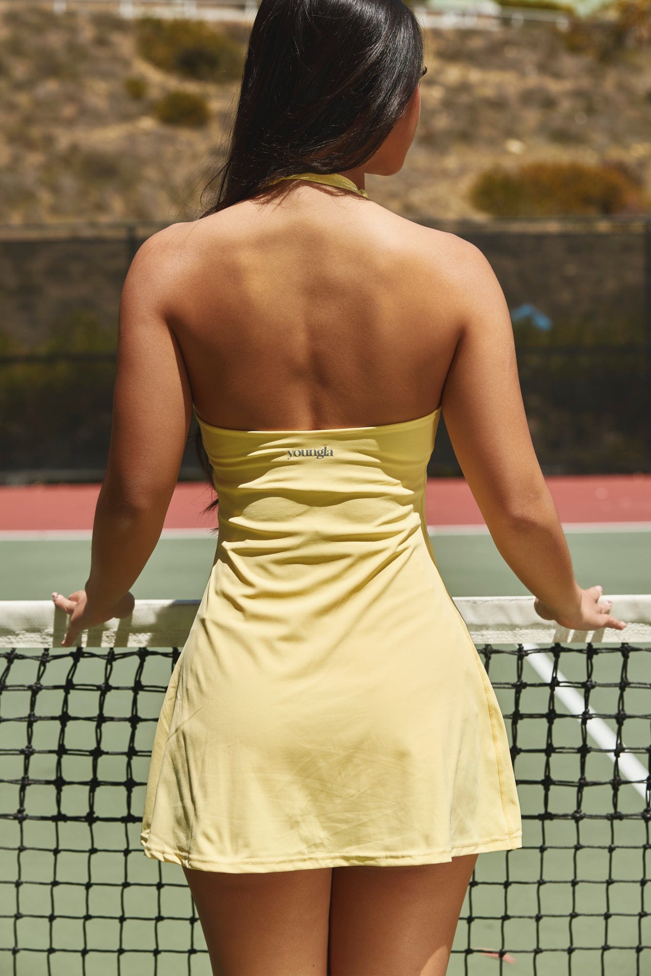 Detail shot of the halter strap and V-neck on the white halter dress