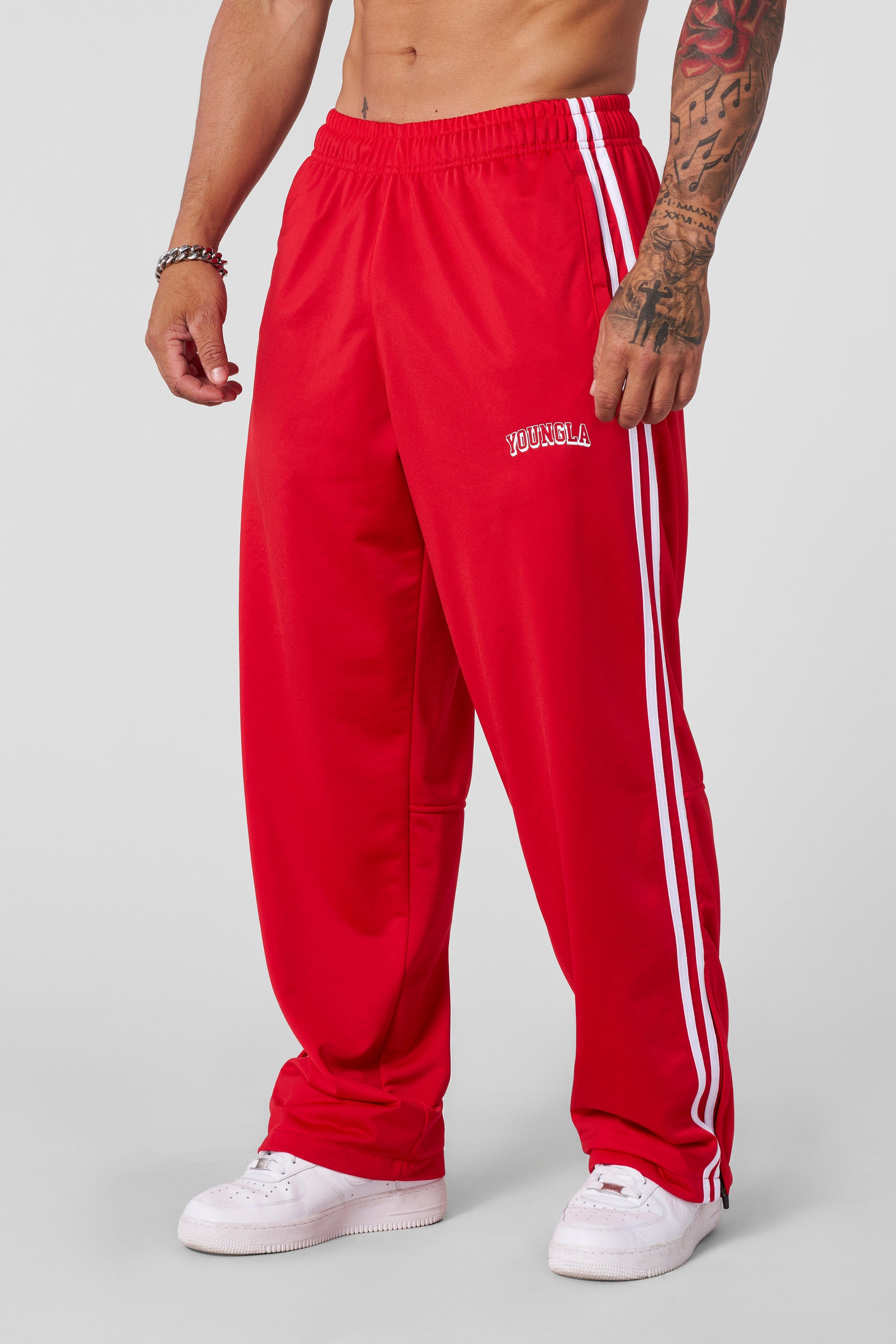 Loose-fit mens track pants styled with casual sneakers on city pavement
