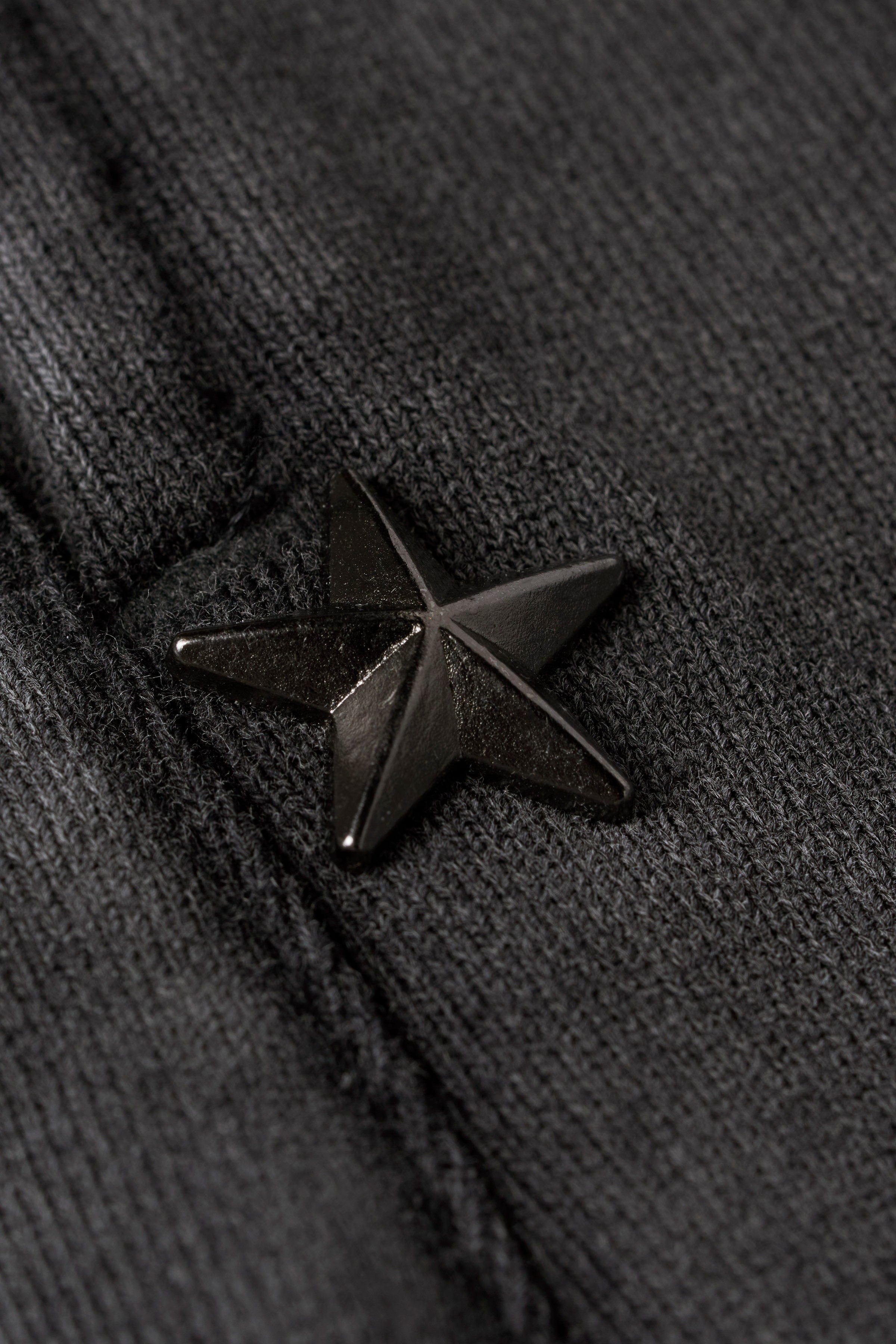 Side view of the baggy gray sweatpants with star patches.