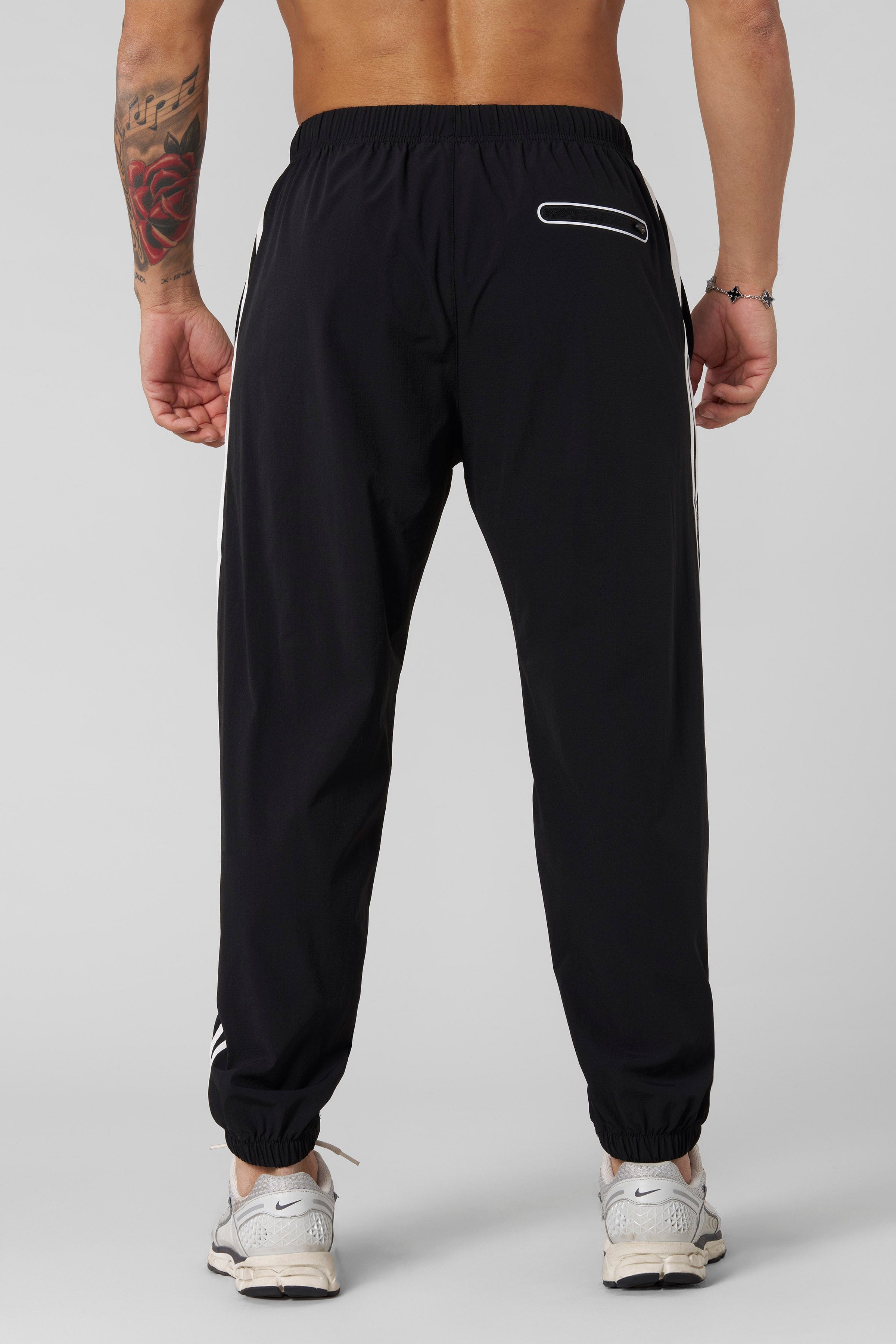 Close-up of joggers cuffed ankles, emphasizing modern athletic design.