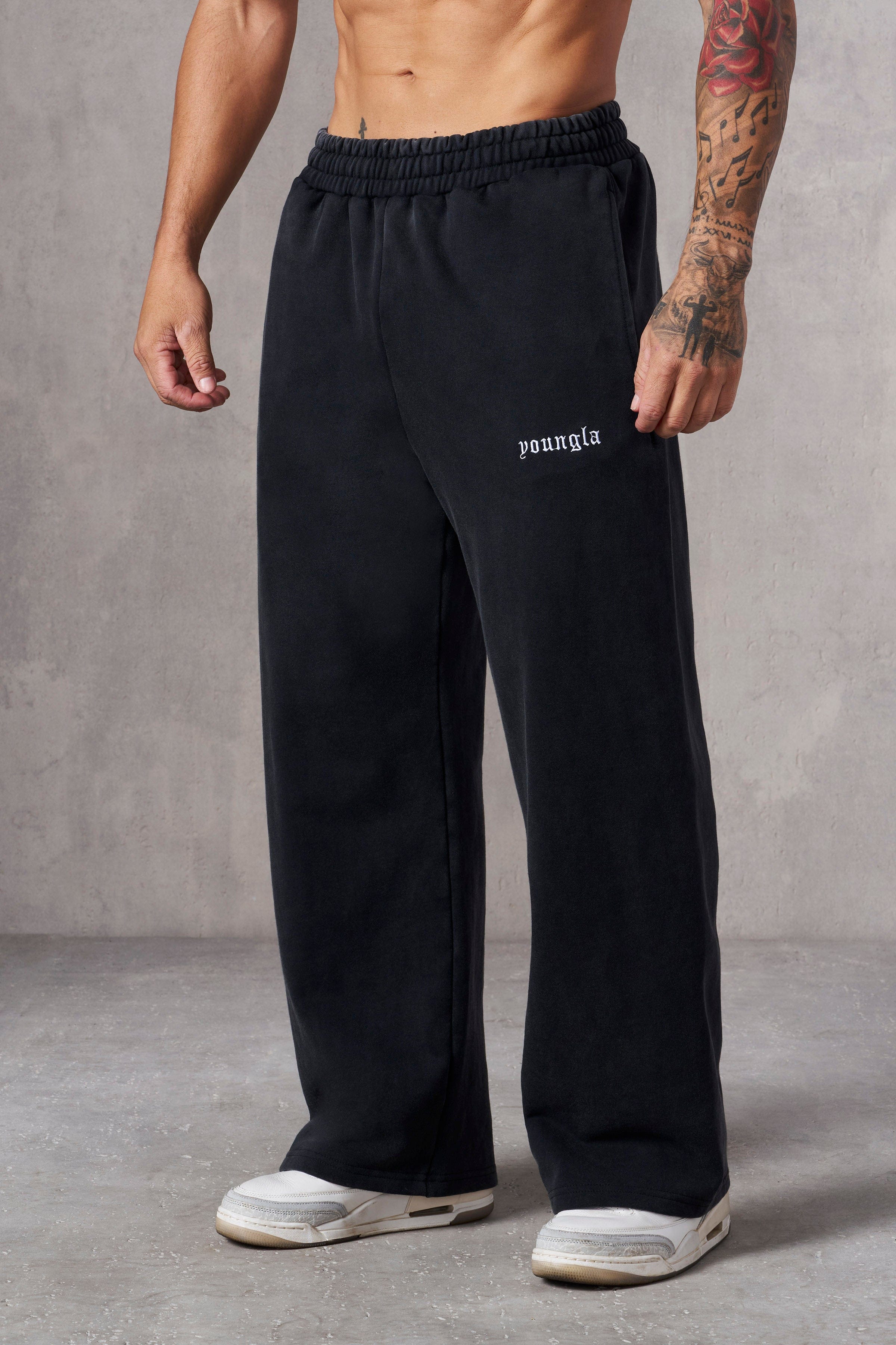 Front view of black baggy sweatpants on a model outdoors.