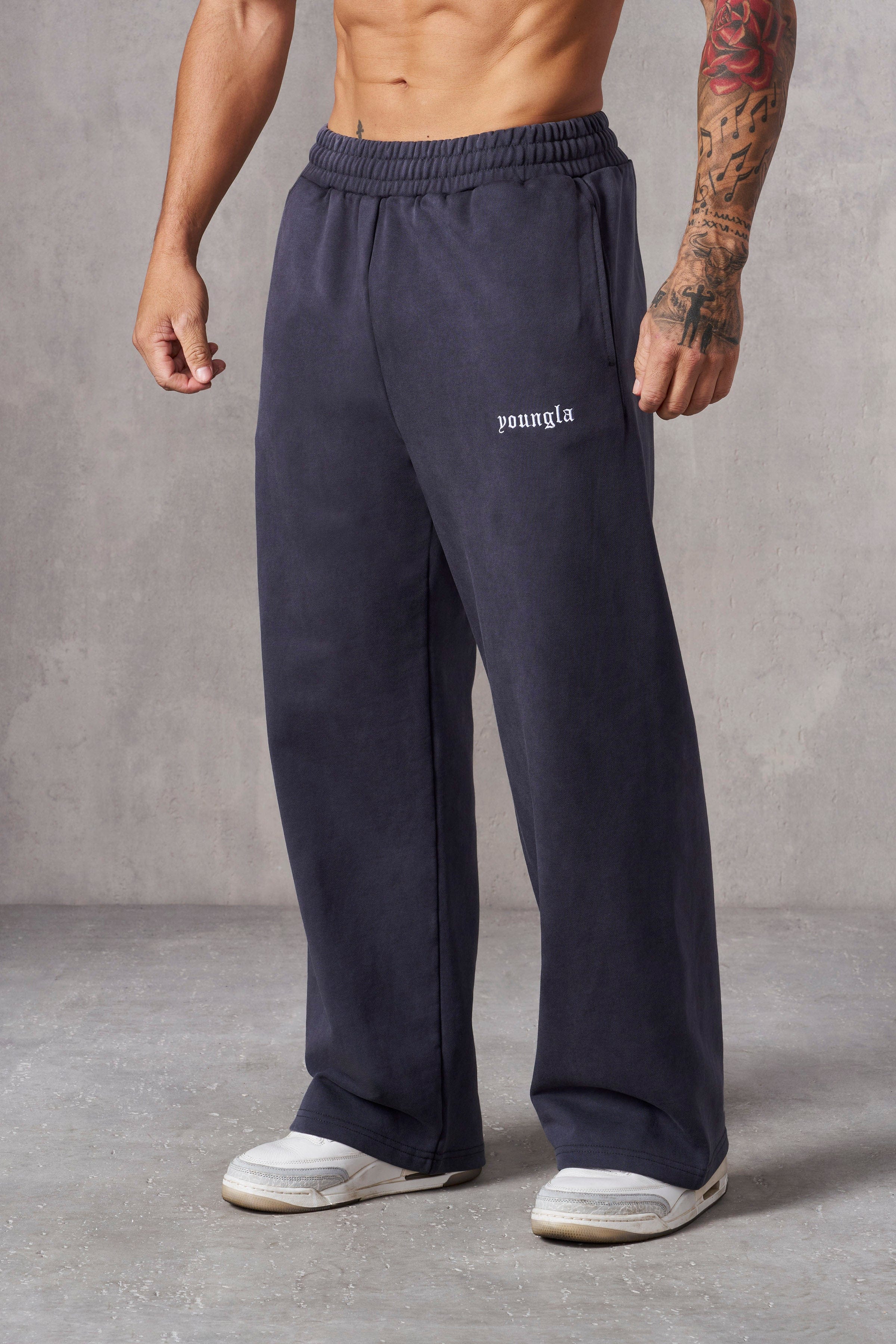 Front view of black baggy sweatpants on a model outdoors.