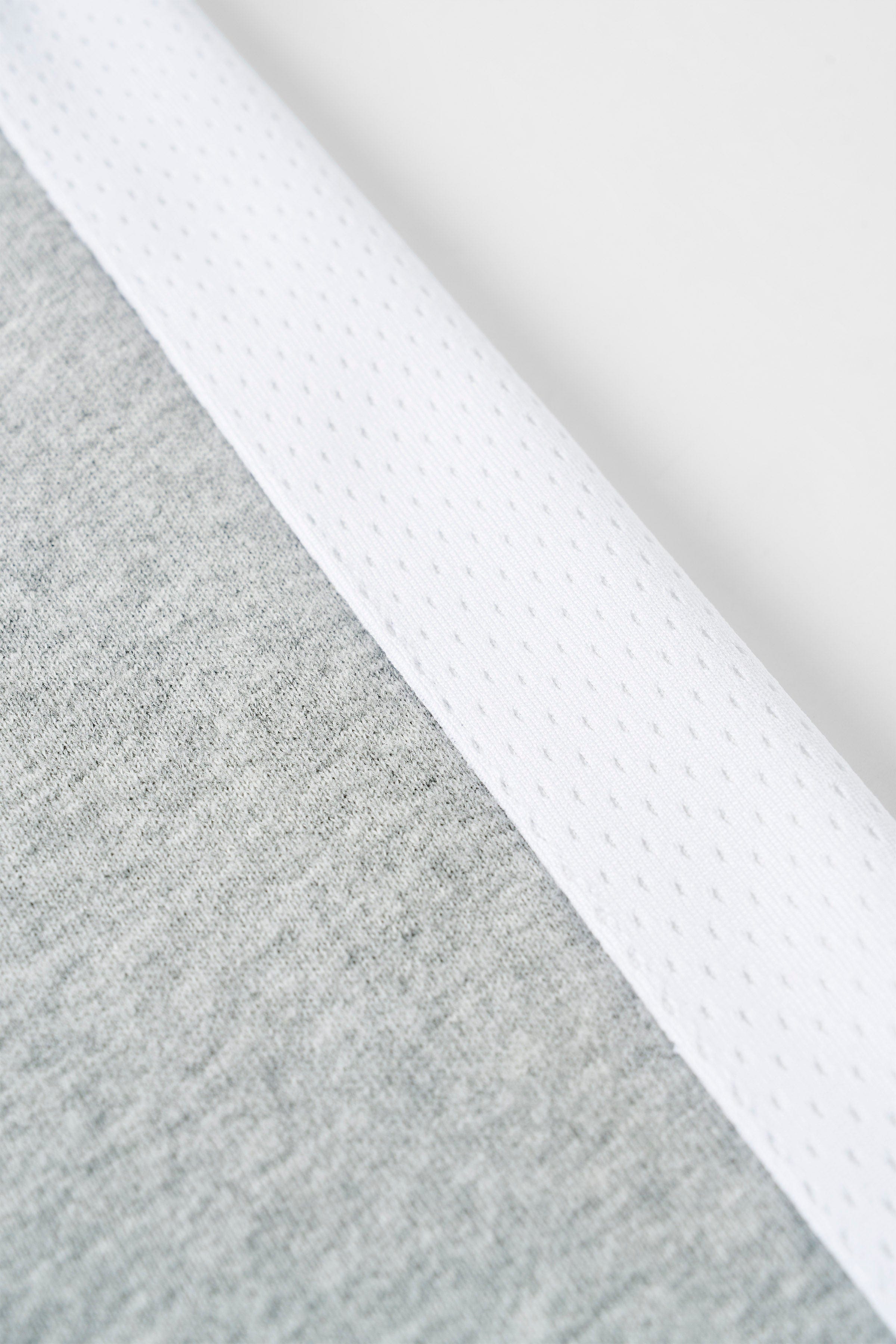 Close-up of grey sweatpants fabric texture and mesh detailing