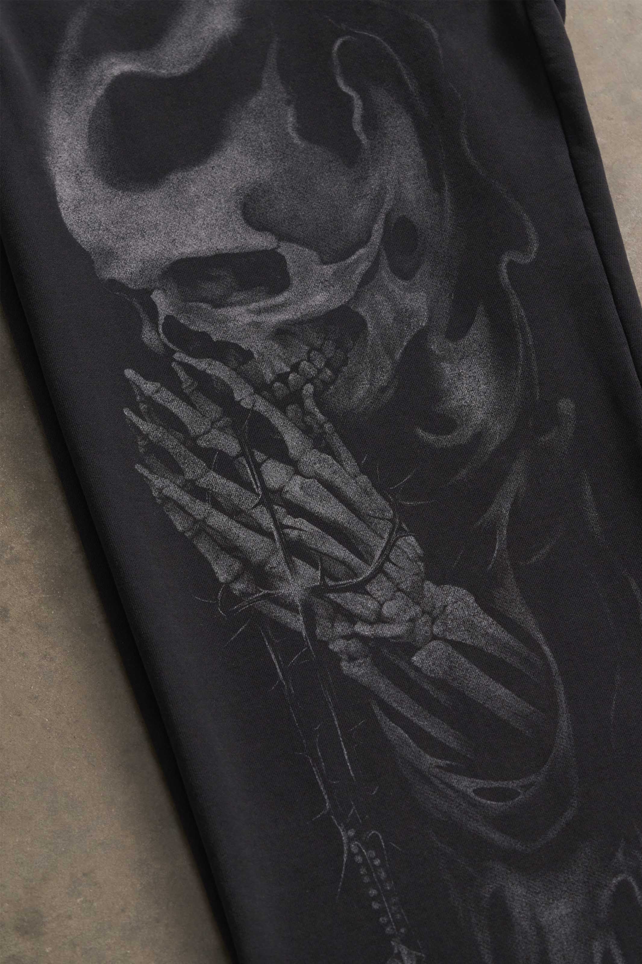 Close-up of skull graphic on black cotton sweatpants