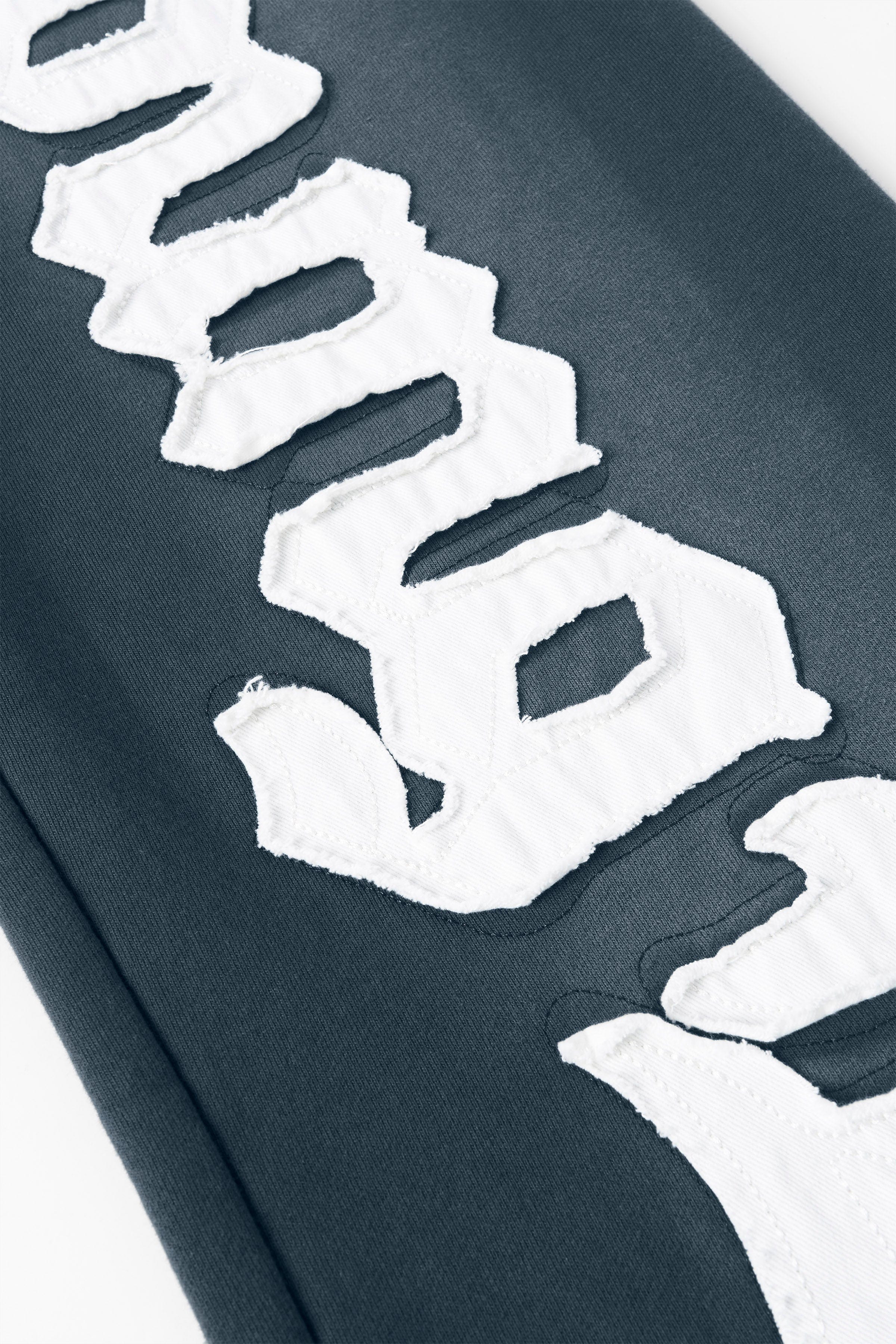 Close-up of the sprayed-wash finish on baggy joggers