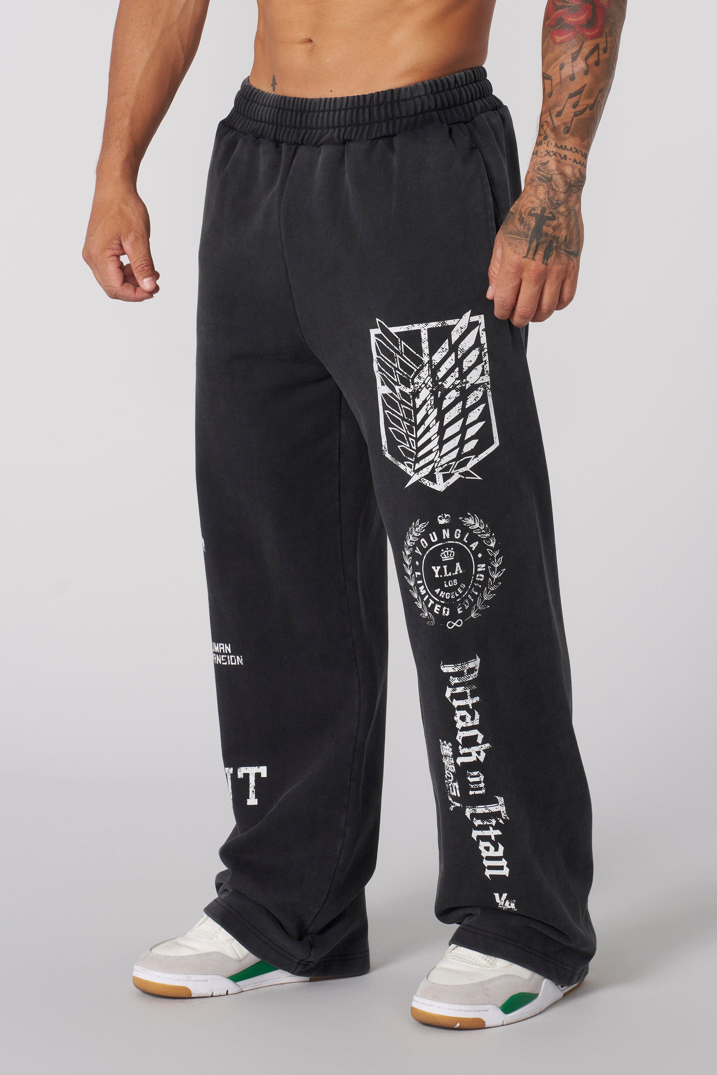 Model wearing black baggy joggers in an urban setting, embodying anime streetwear style.