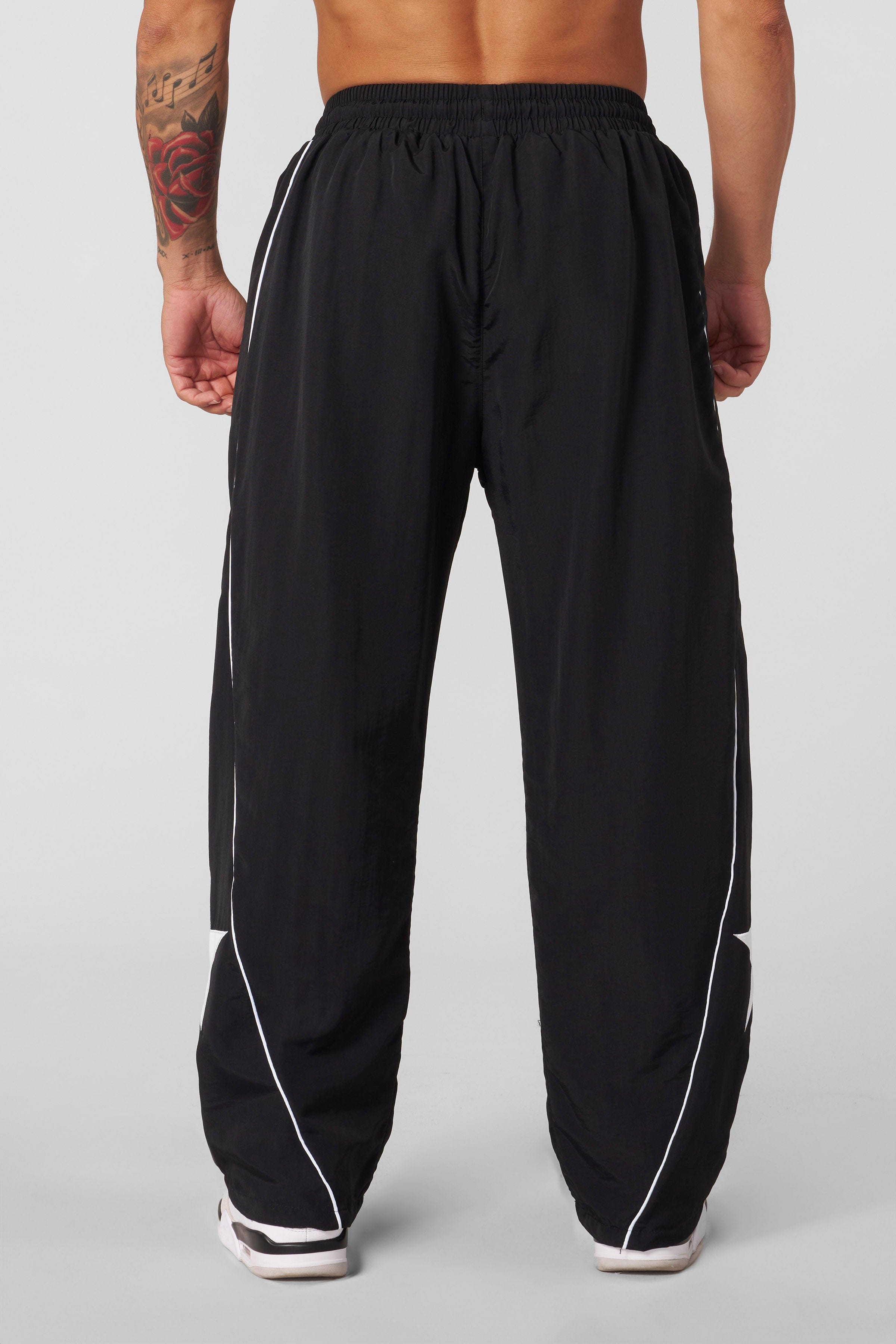 Front view of YoungLA x UFC tracksuit pants showcasing side piping and star patch