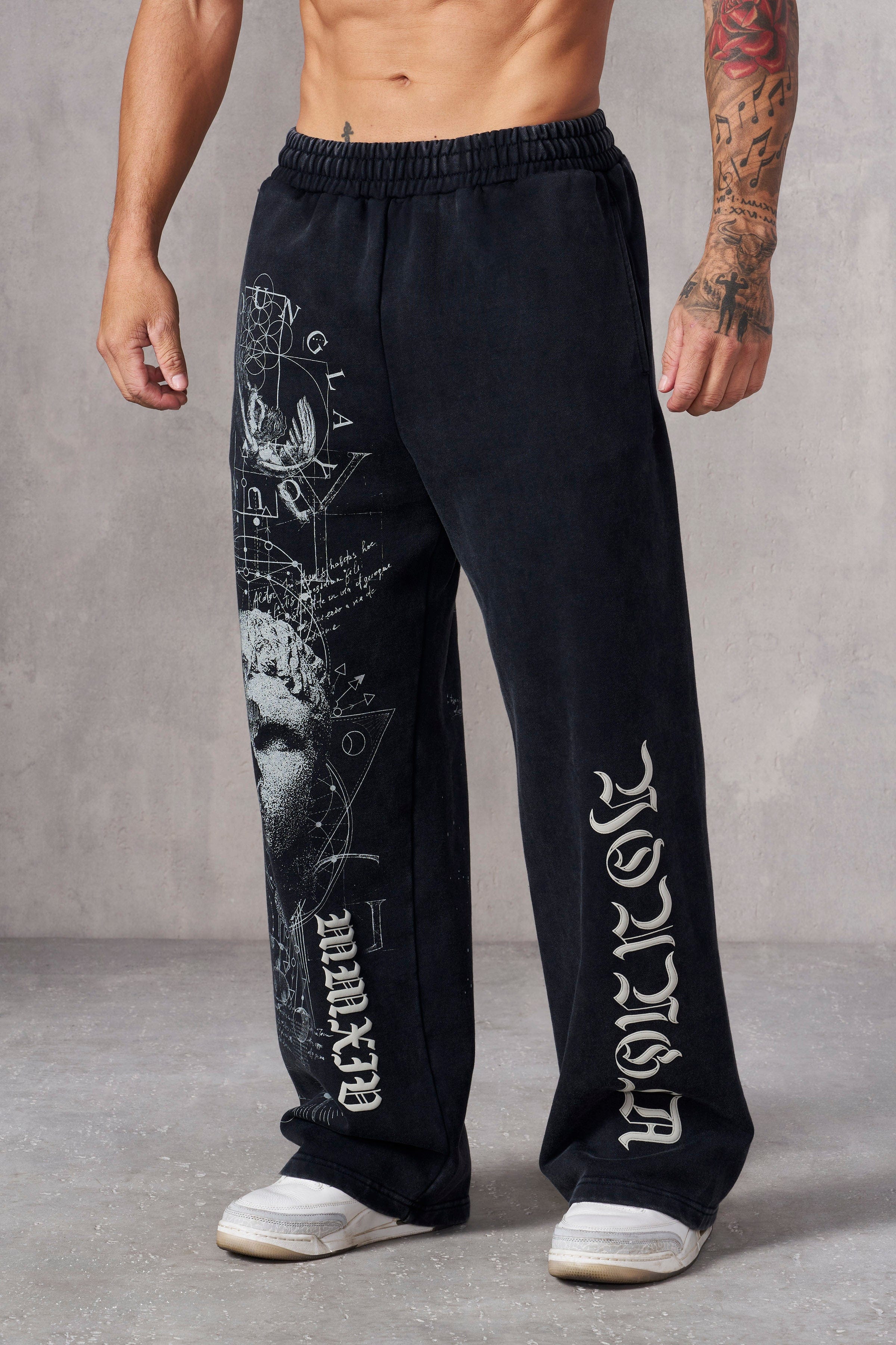 Men's baggy sweat pants with intricate graphic tattoo print, front view