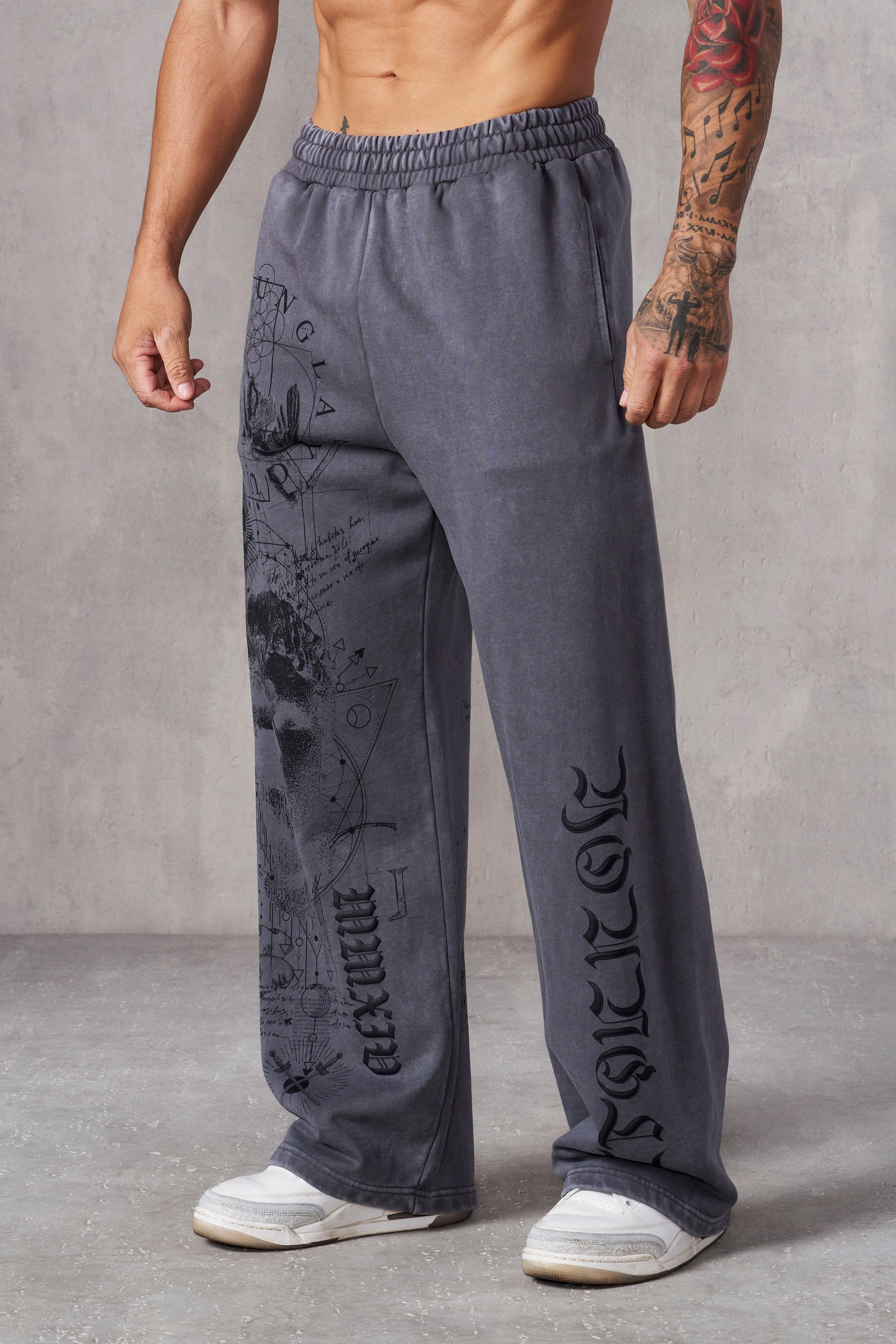 Mens baggy sweat pants with intricate graphic tattoo print, front view