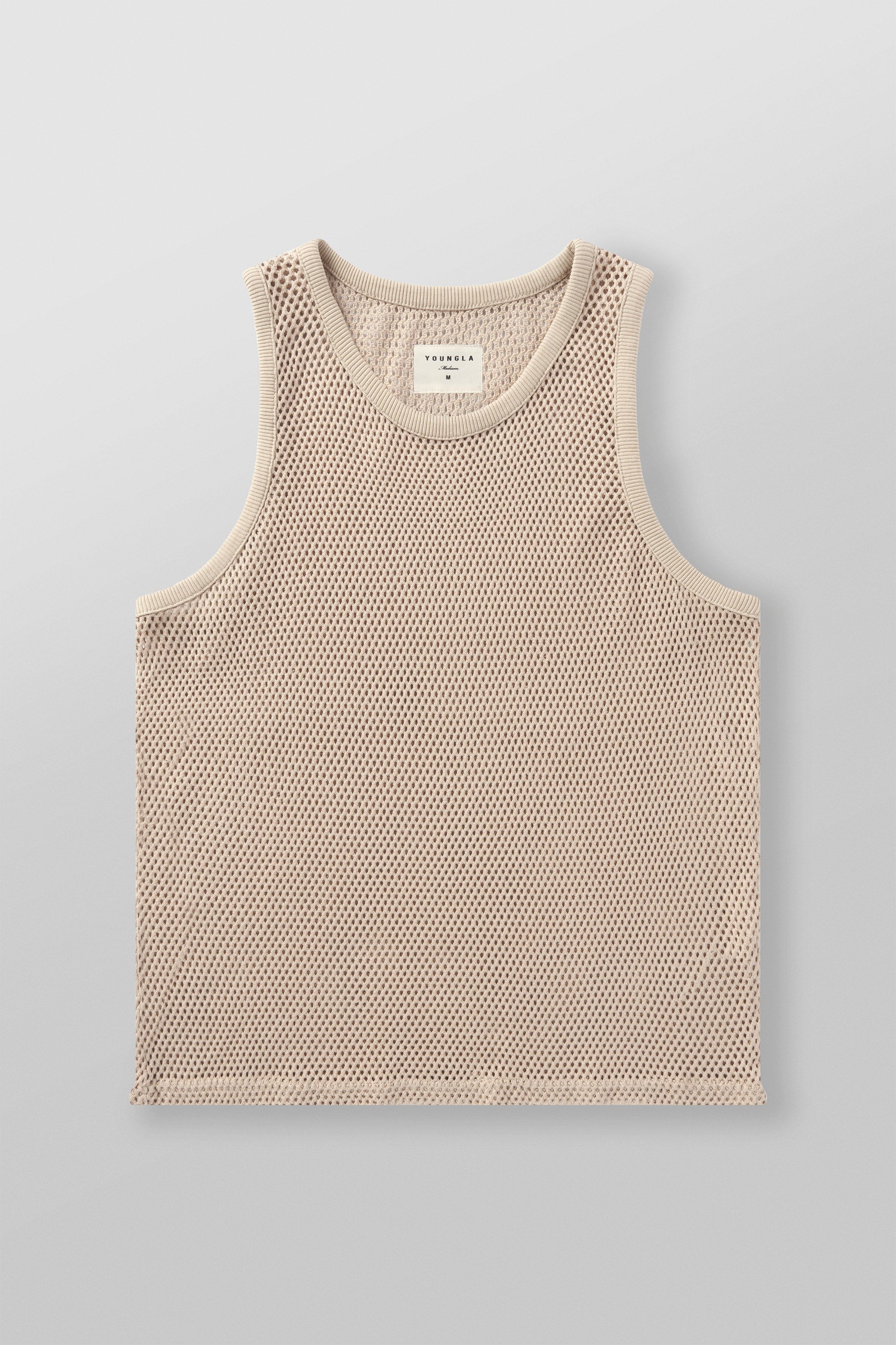 Male model wearing a mesh tank top on a sunny day.