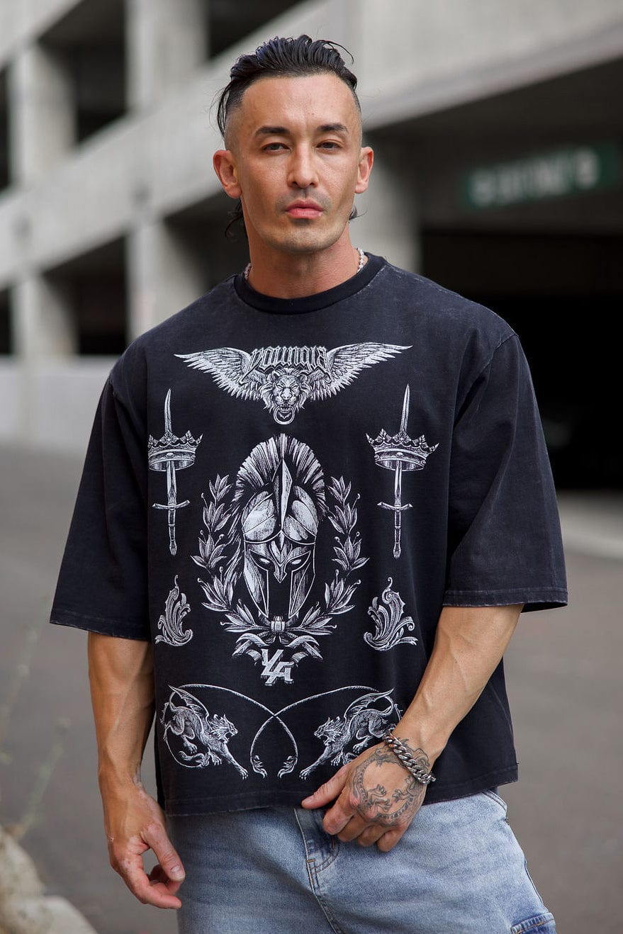 Back close-up showing crown and sword artwork on oversized t-shirt fabric.