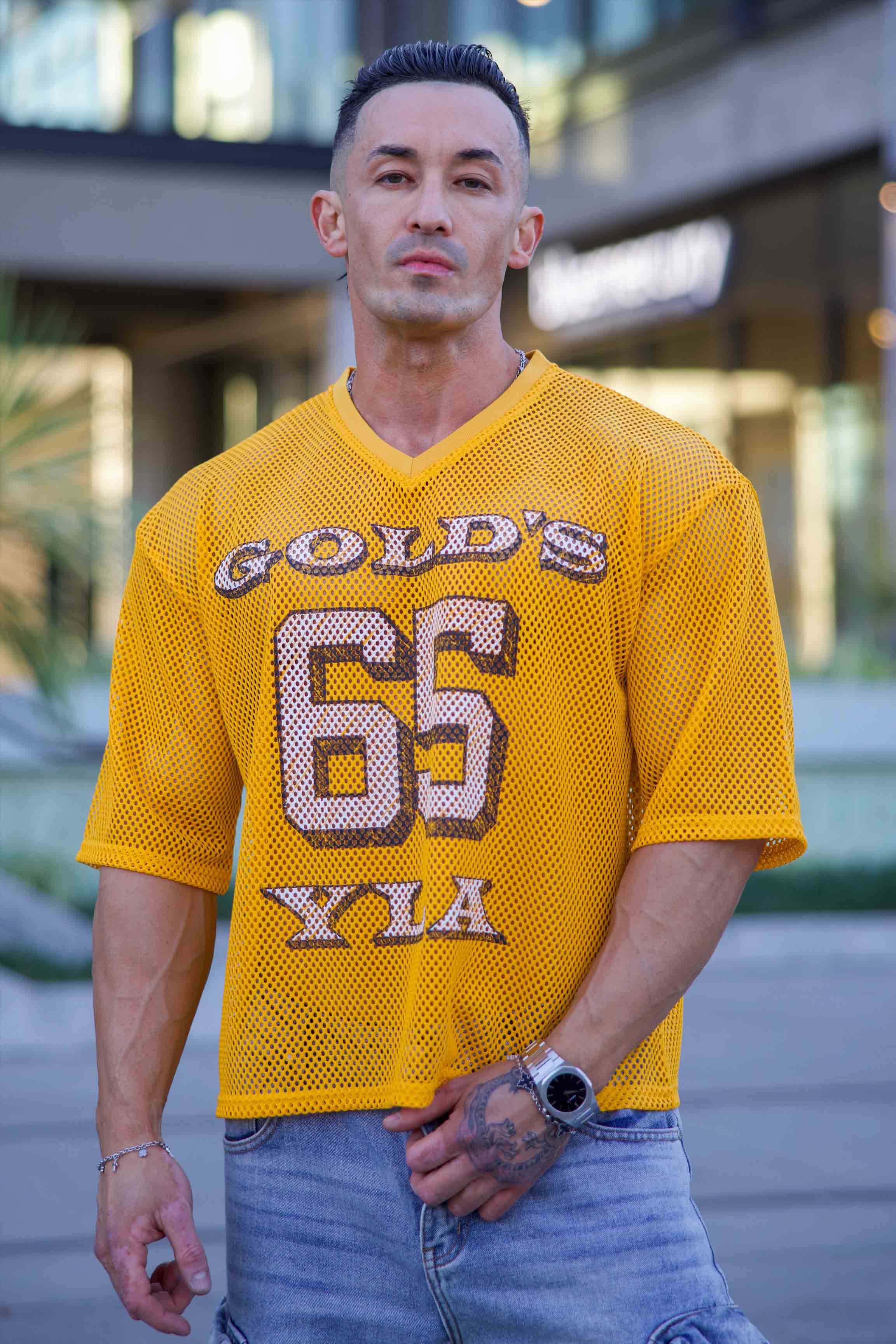 Model wearing the Golds Gym x YoungLA Mesh Jersey at the gym, highlighting its stylish design.