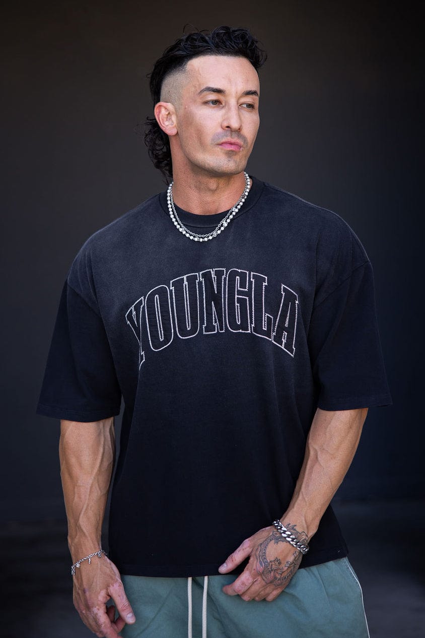 Side angle of oversize t shirt with arched logo, worn casually on urban street