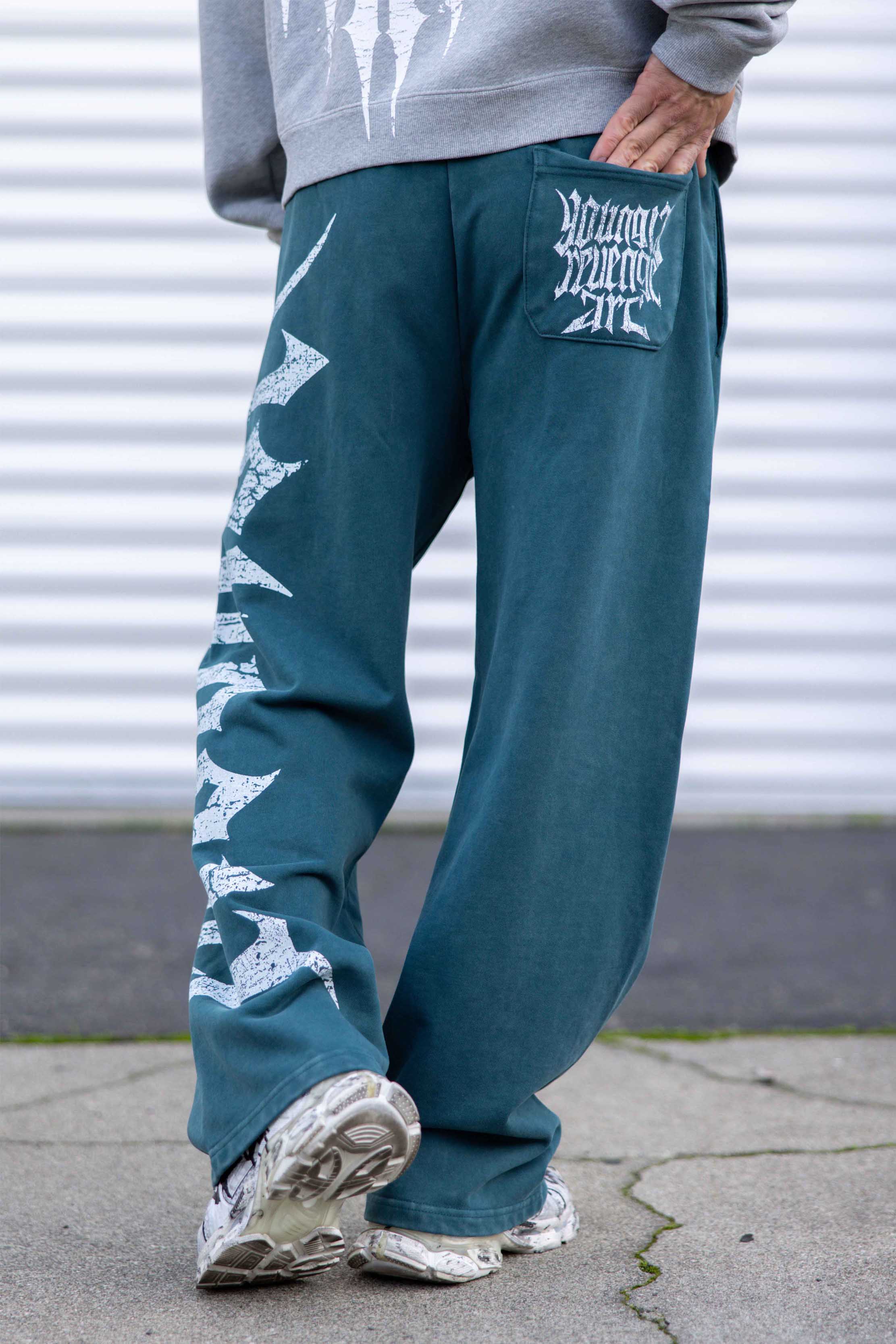 Full-body shot of model wearing black joggers styled with hoodie in urban setting