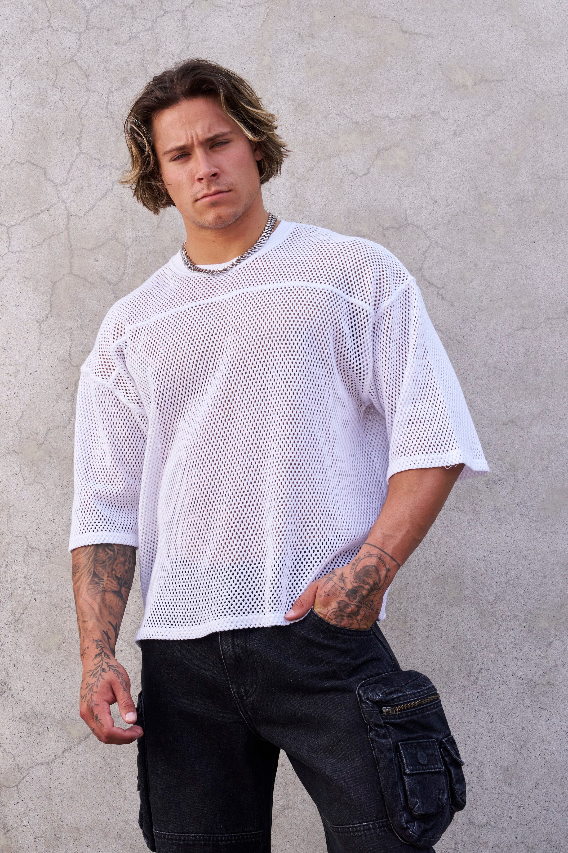 Man wearing an oversized cotton mesh tee with relaxed fit, standing outdoors