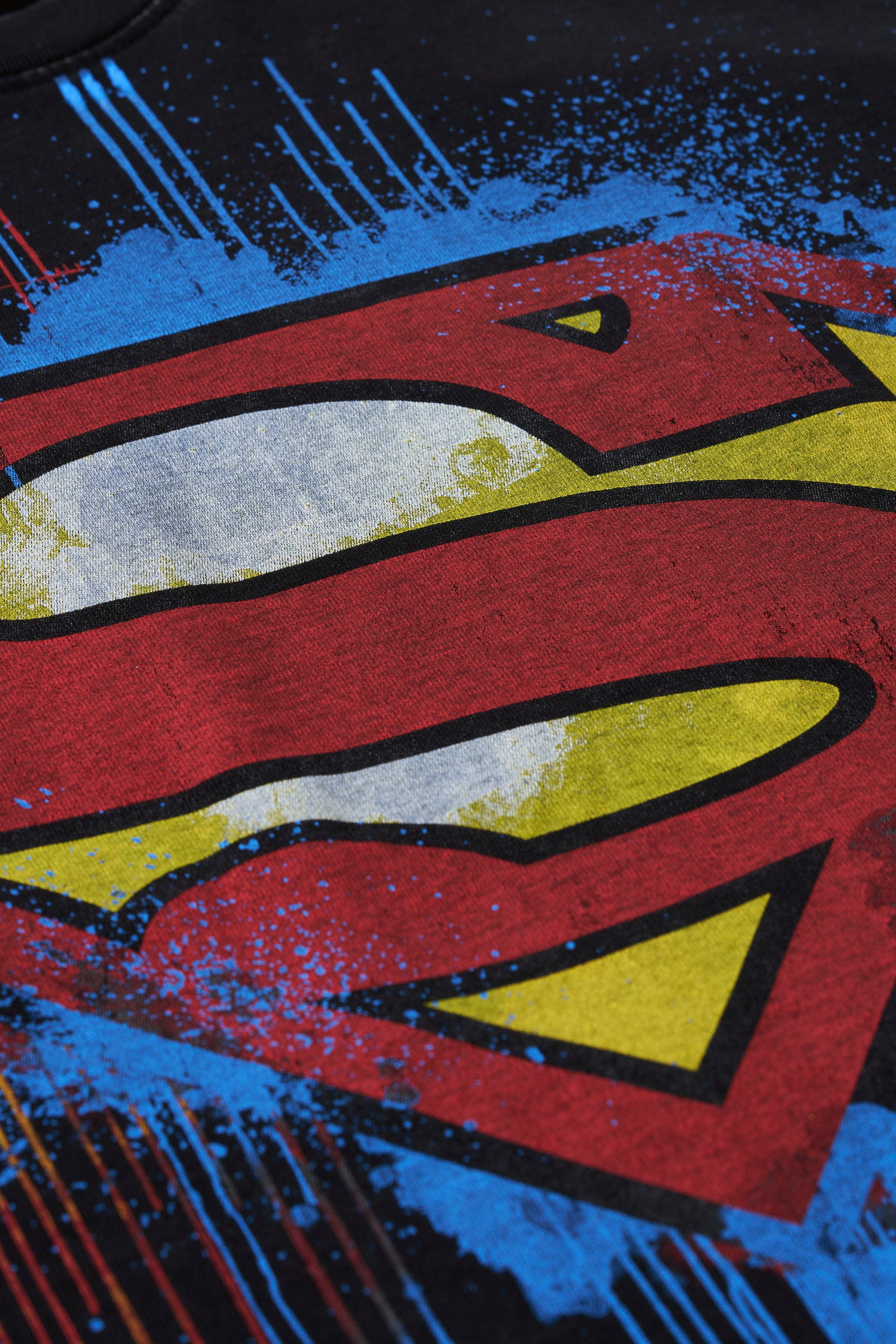 Close-up of the unique Superman design on the vintage graphic tee.