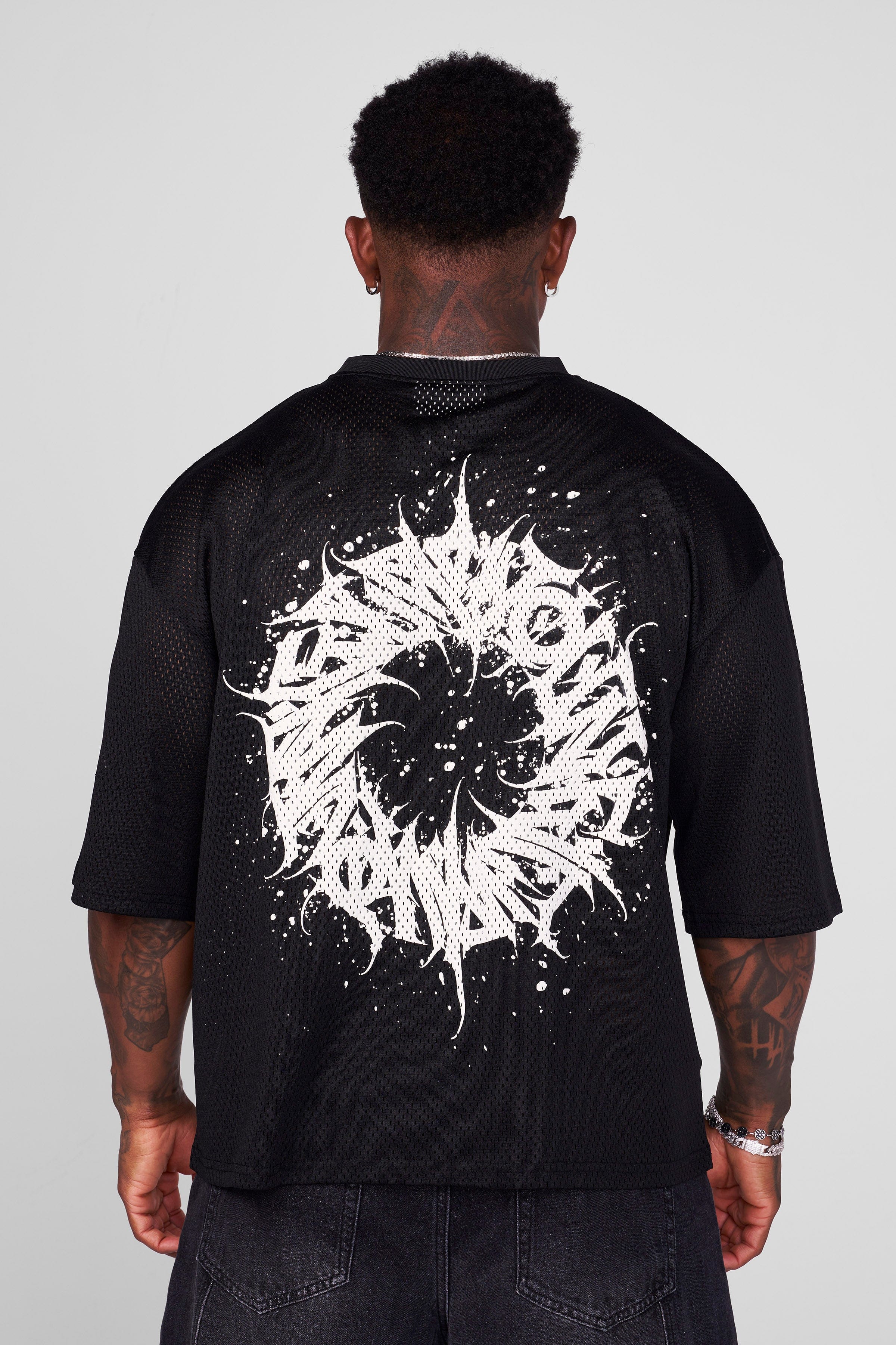 Rear view of mesh football jersey with reflective details.