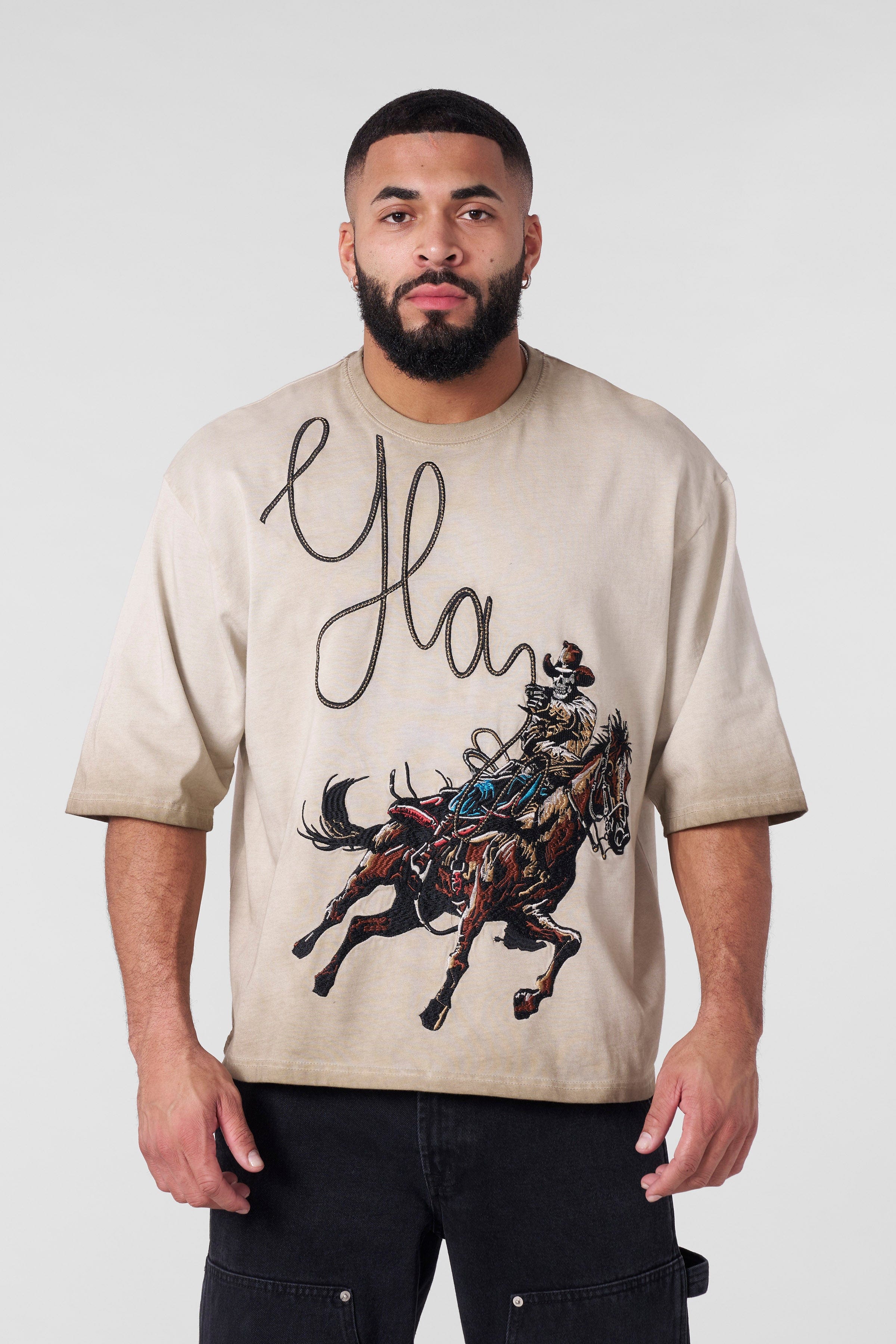 Model wearing the boxy fit cowboy t shirt in a casual setting.