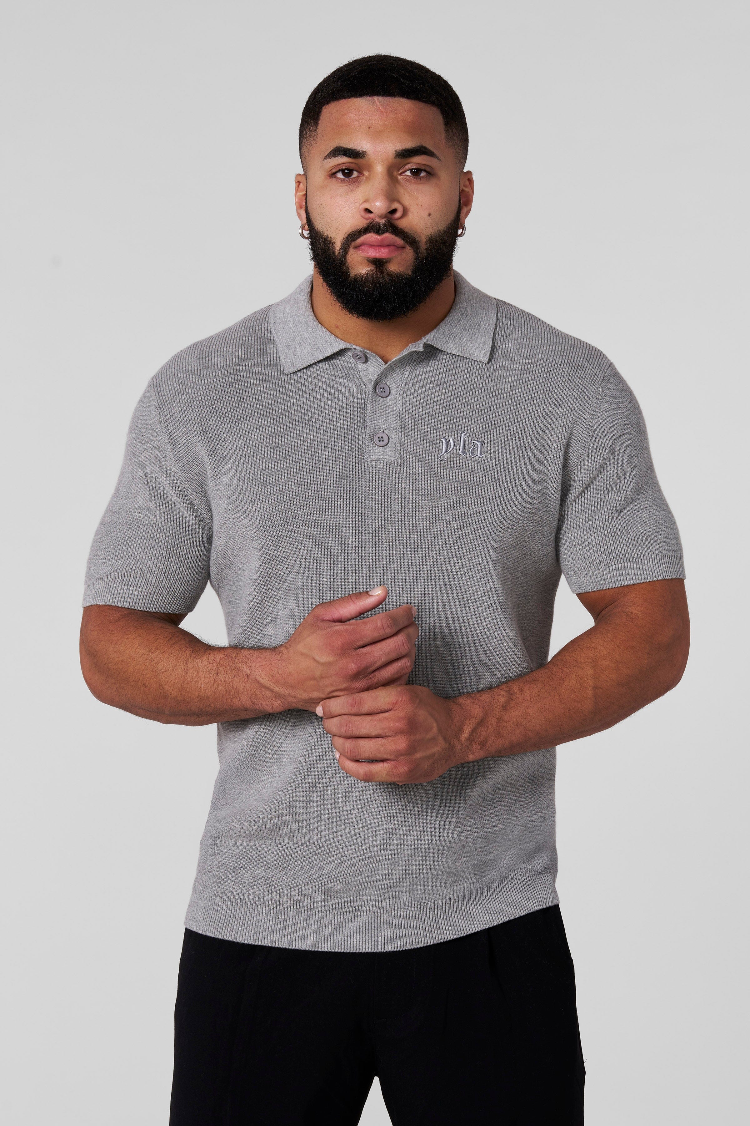Front view of a fitted knit polo in classic white, ideal for smart casual outings