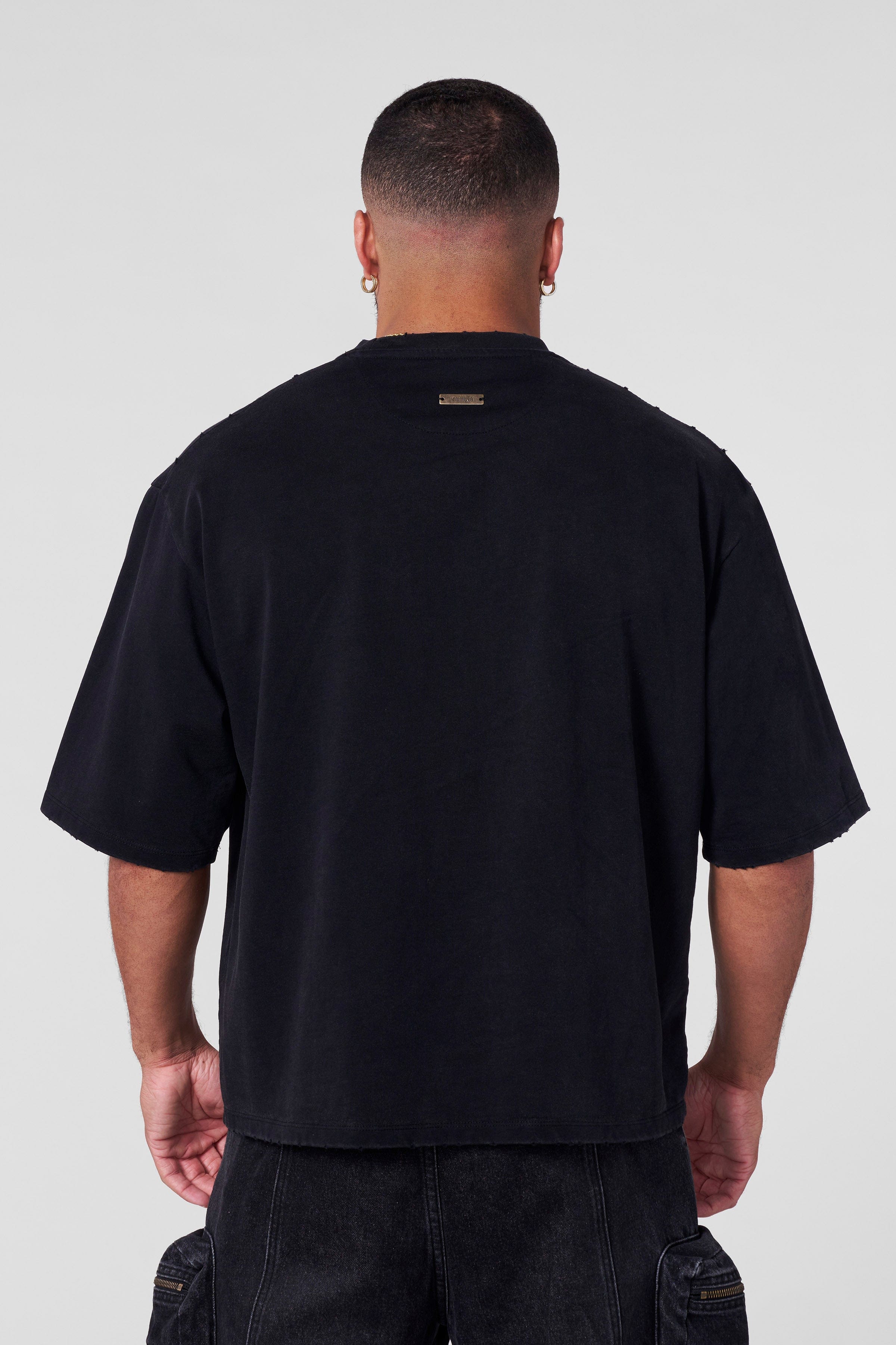 Close-up of raw cut holes showcasing distressed tees texture in oversize t shirt