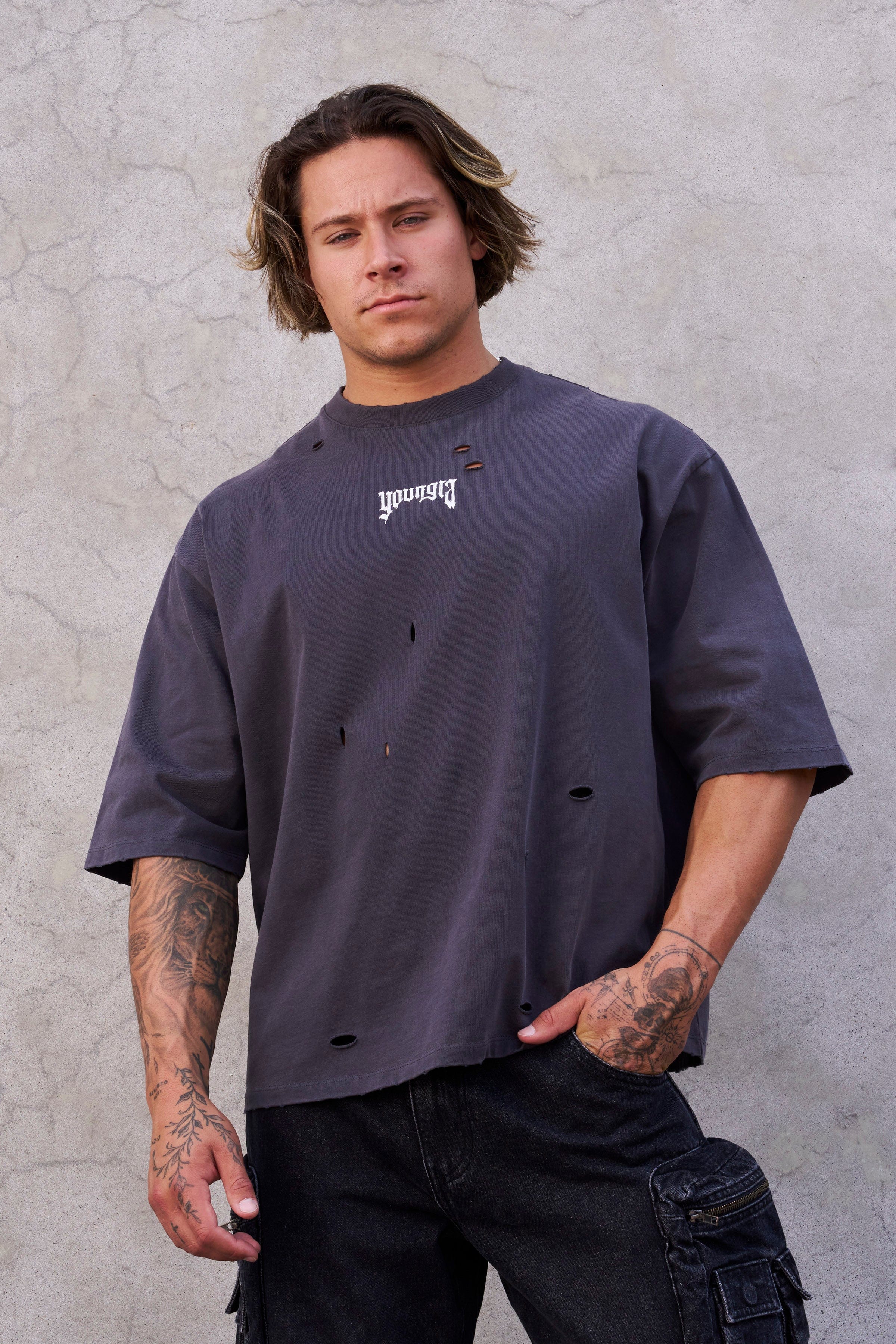 Side view of model wearing oversized t shirt men version with ripped detailing