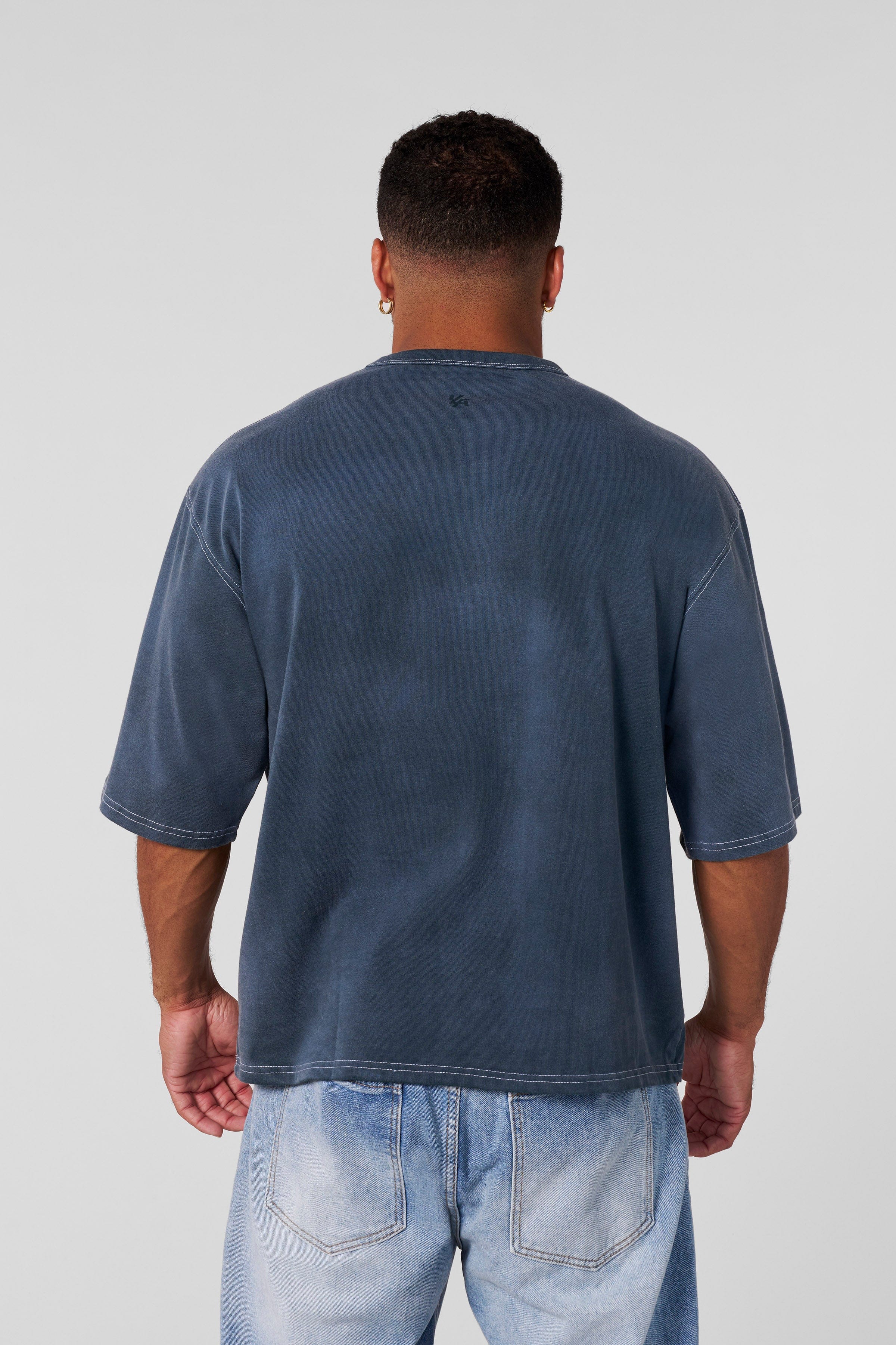 Front view of oversized cotton t shirt with shadow logo on neutral background