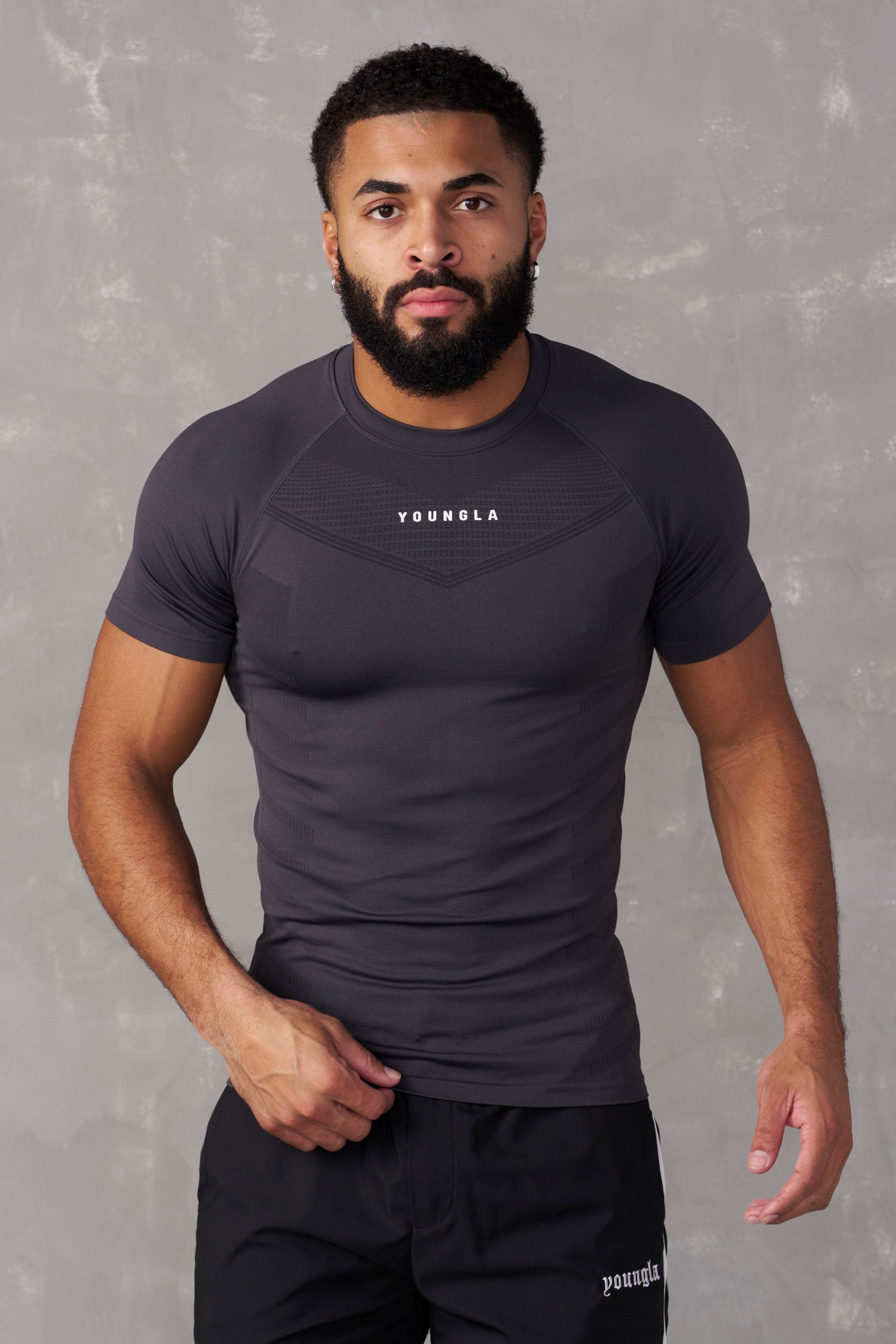 Front view of SuperVillain compression shirt on a man lifting weights.