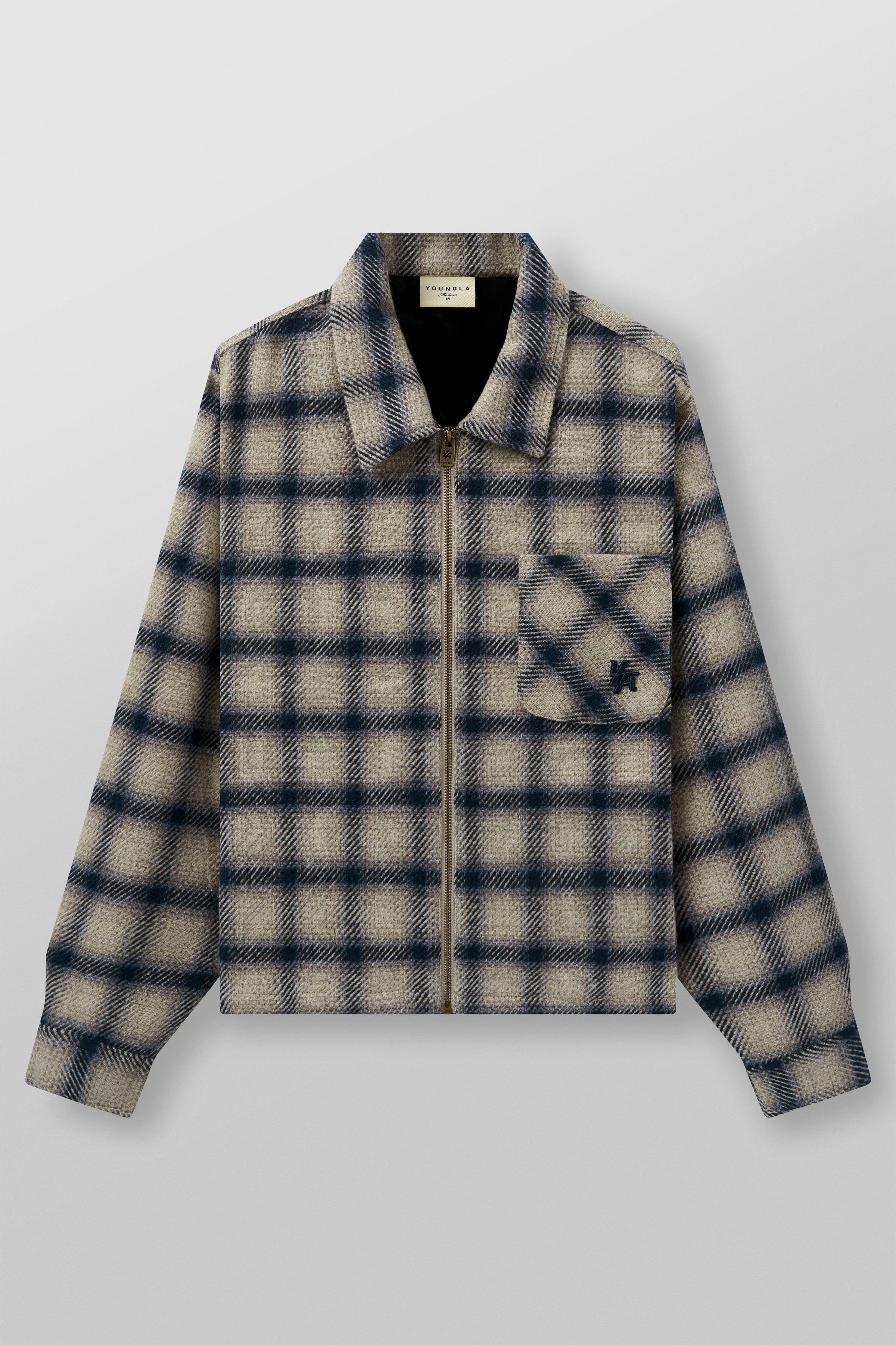 Jacket hanging on a wooden hook, showcasing its loose fit and zip closure.