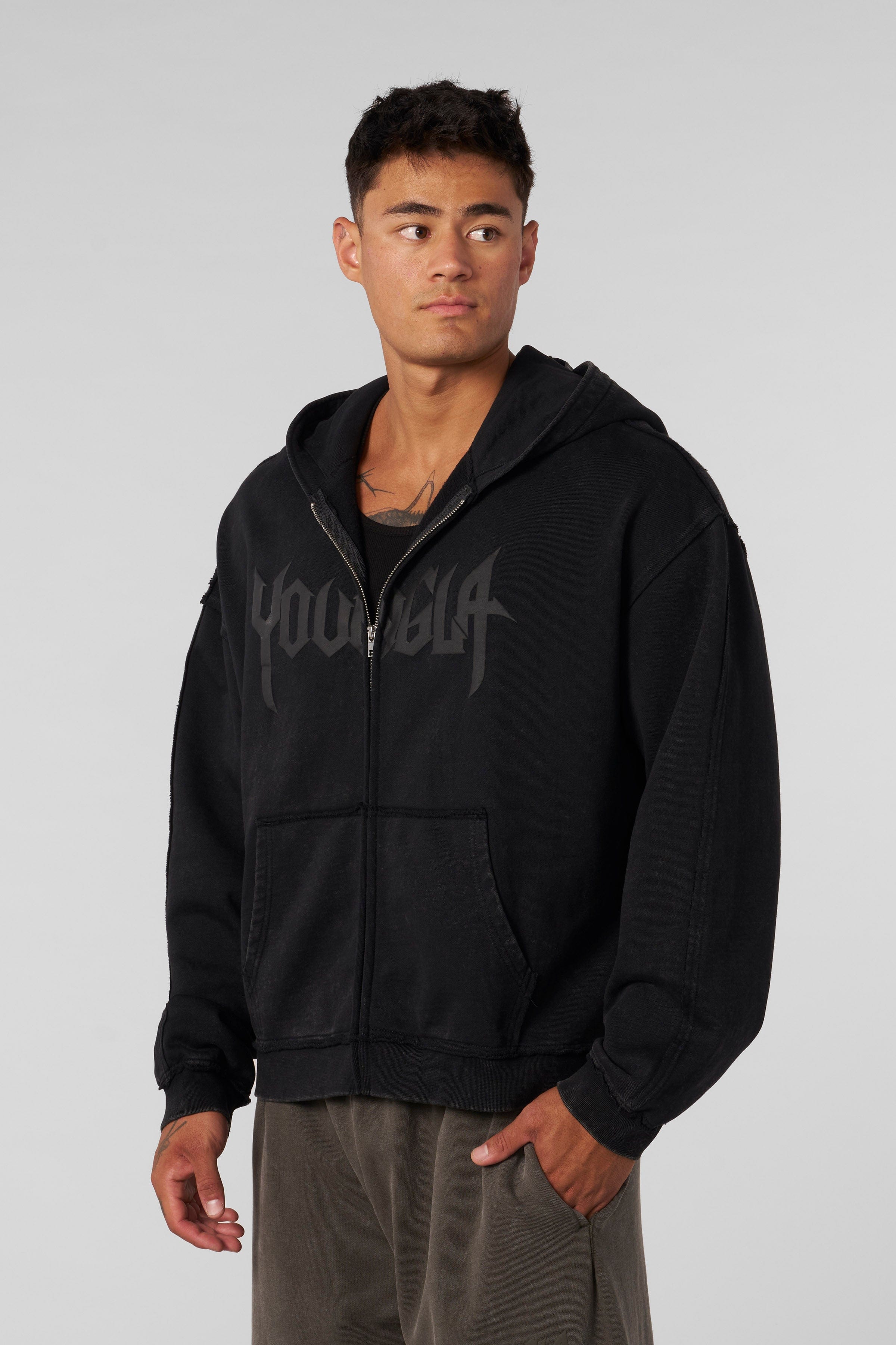 Close-up of chest branding and raw-cut sleeve finish on vintage hoodie.