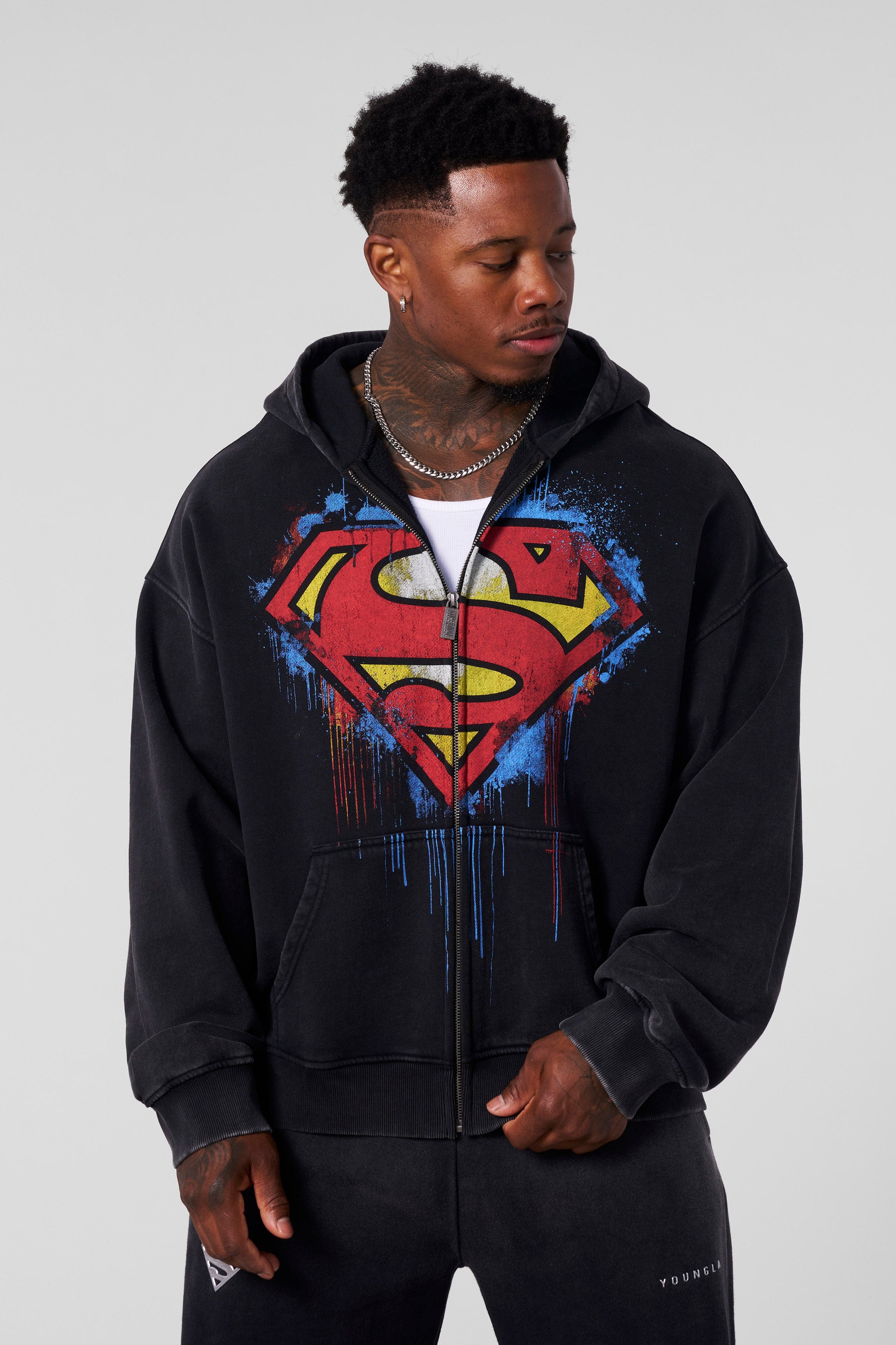 Close-up of the Superman logo on the oversized hoodie, highlighting its vibrant colors.