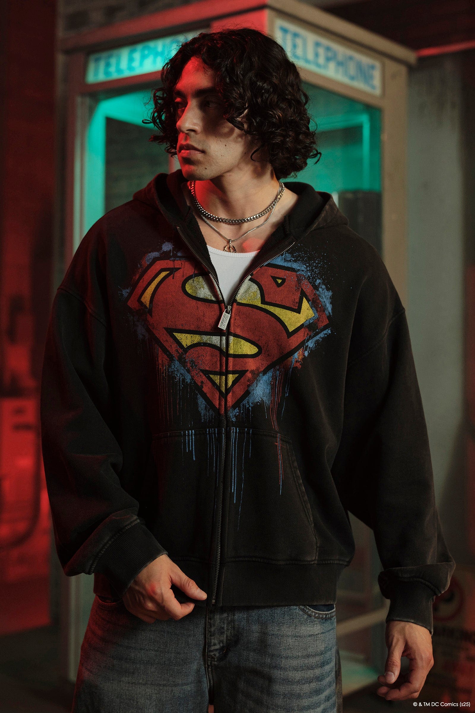 Side view of the model wearing the Superman zip-up sweatshirt, showcasing its relaxed fit.