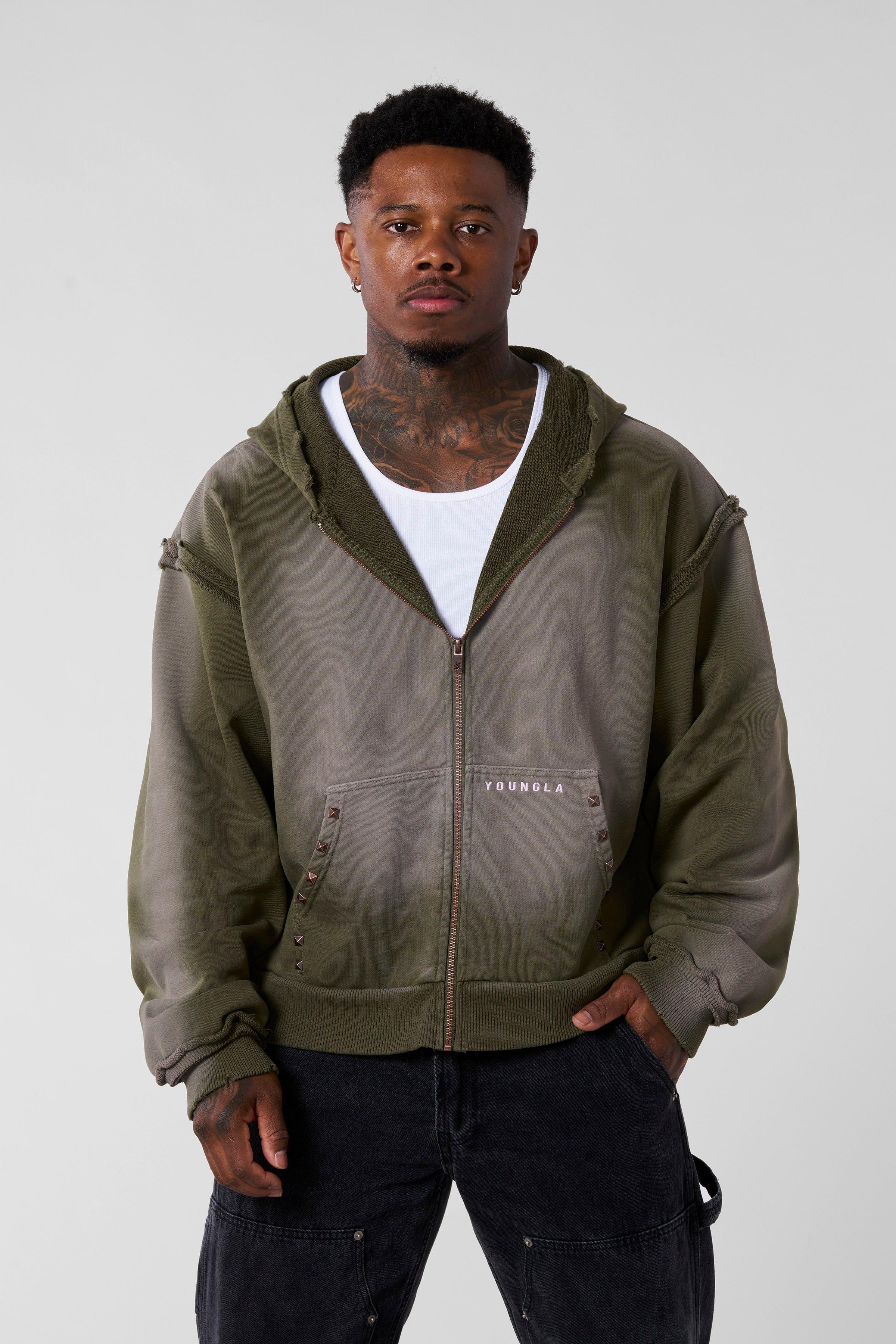 Close-up of raw seams and studs on the pocket of the oversized hoodie