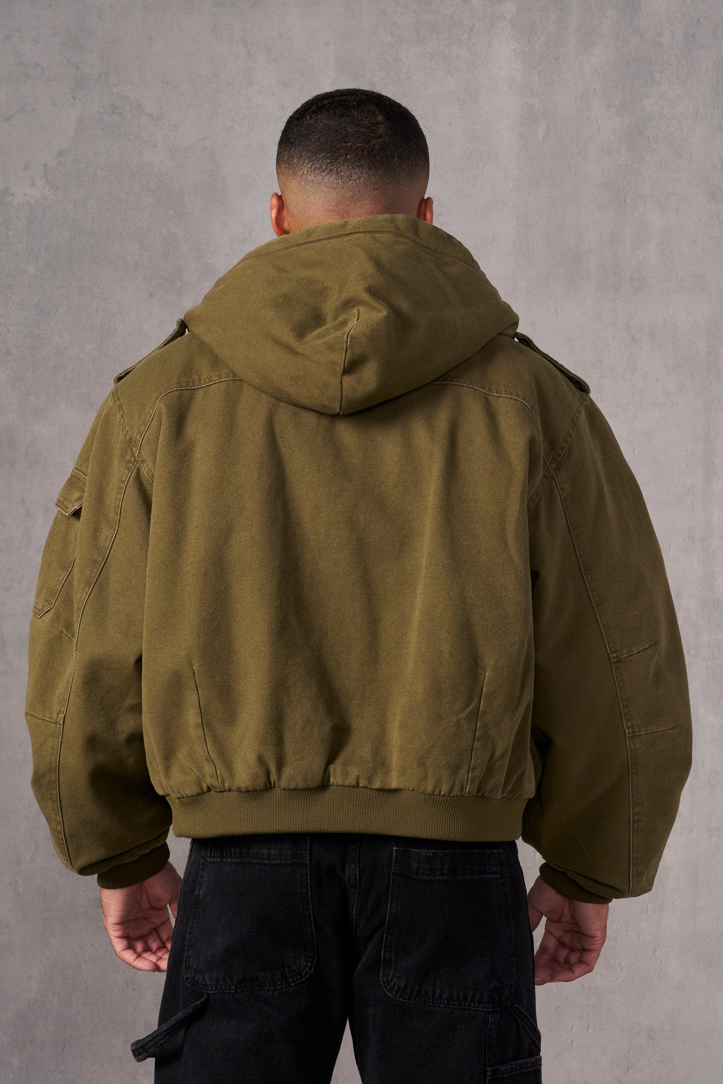 Close-up of a brown leather aviator jacket showcasing shoulder studs and stitching