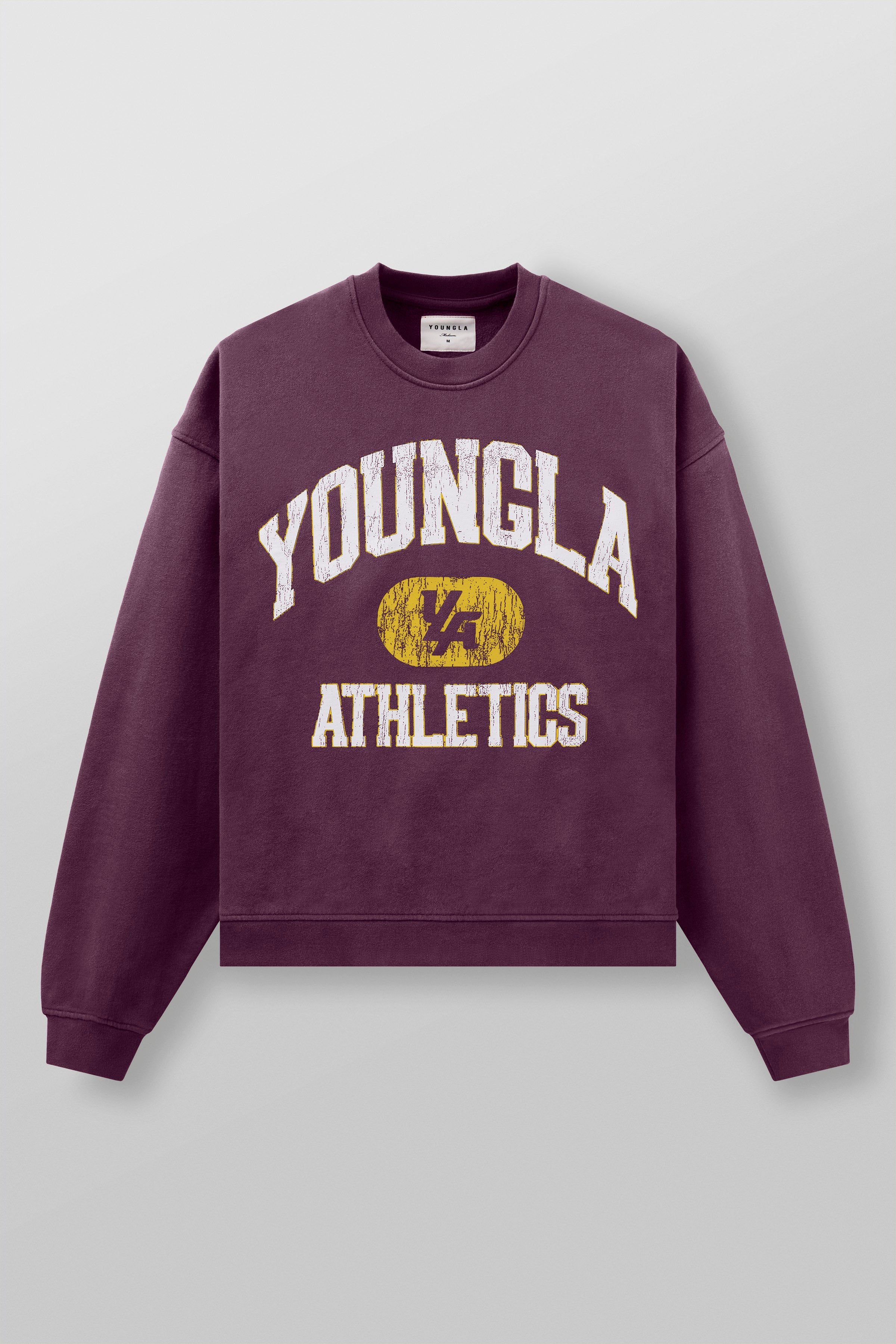 Front angle of model wearing oversized black crewneck with varsity print in urban setting