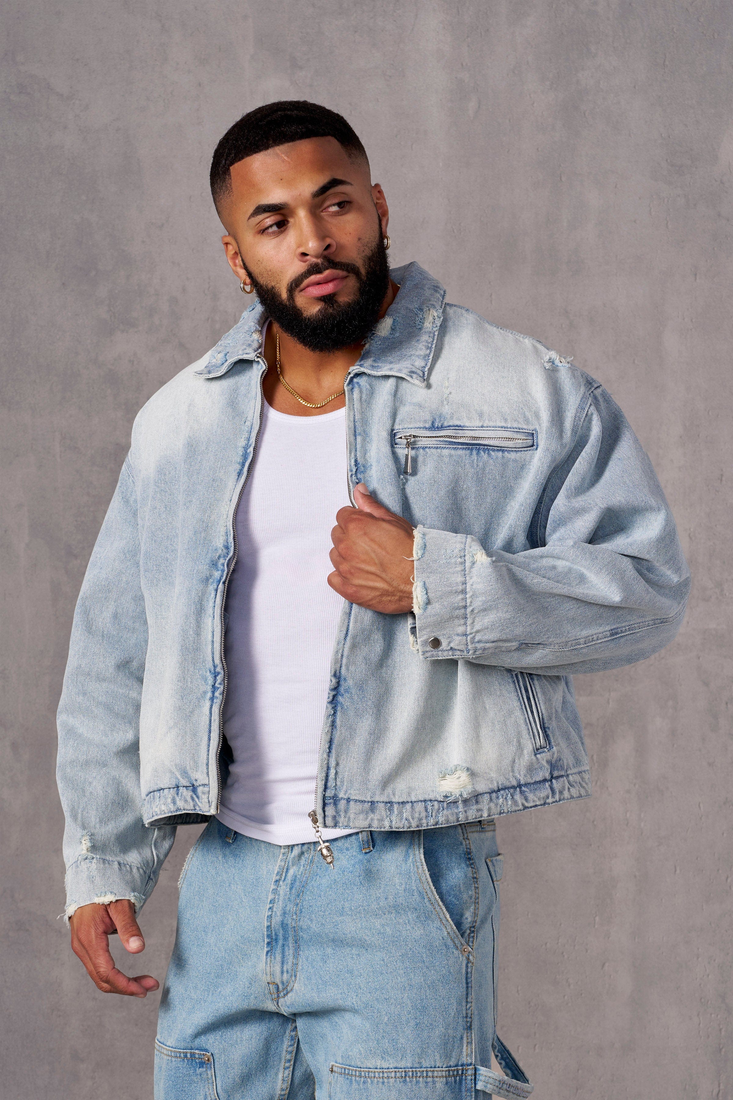 Front view of cropped denim jacket worn by male model outdoors