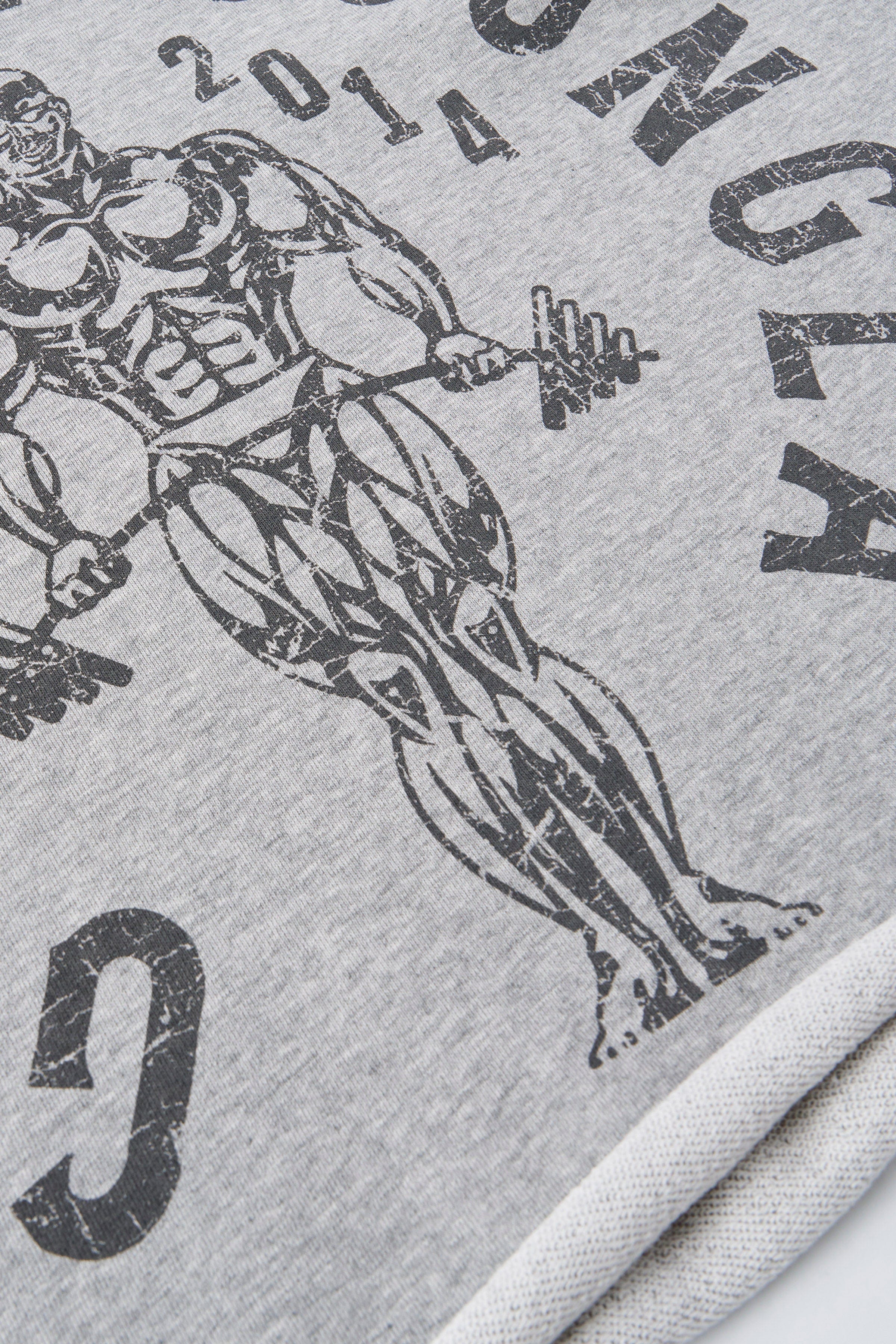 Side angle of cut off gym shirt highlighting distressed details.
