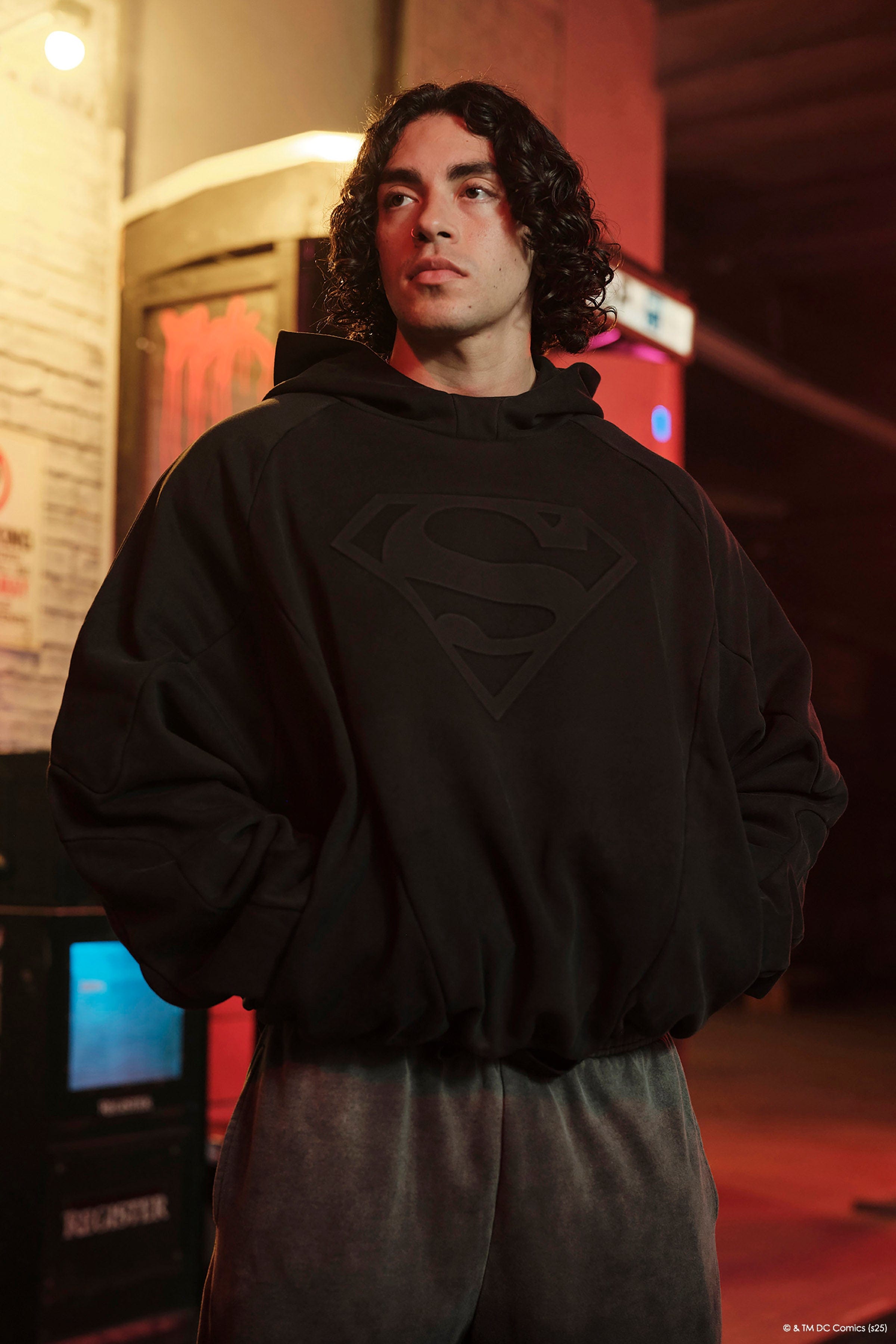 Front view of Superman hoodie for men worn in urban setting.