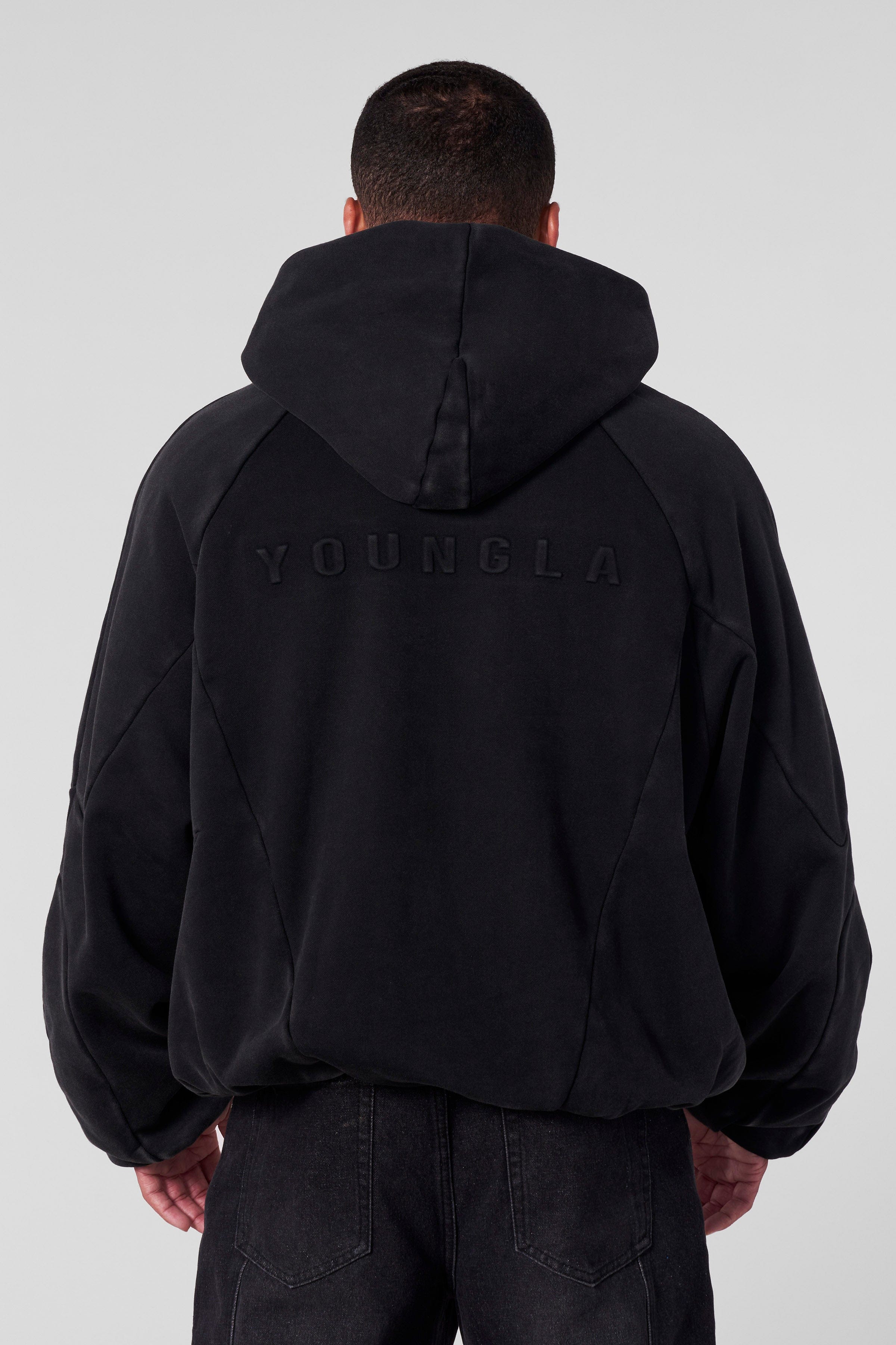 Embossed Superman shield hoodie logo shot with close-up detail.