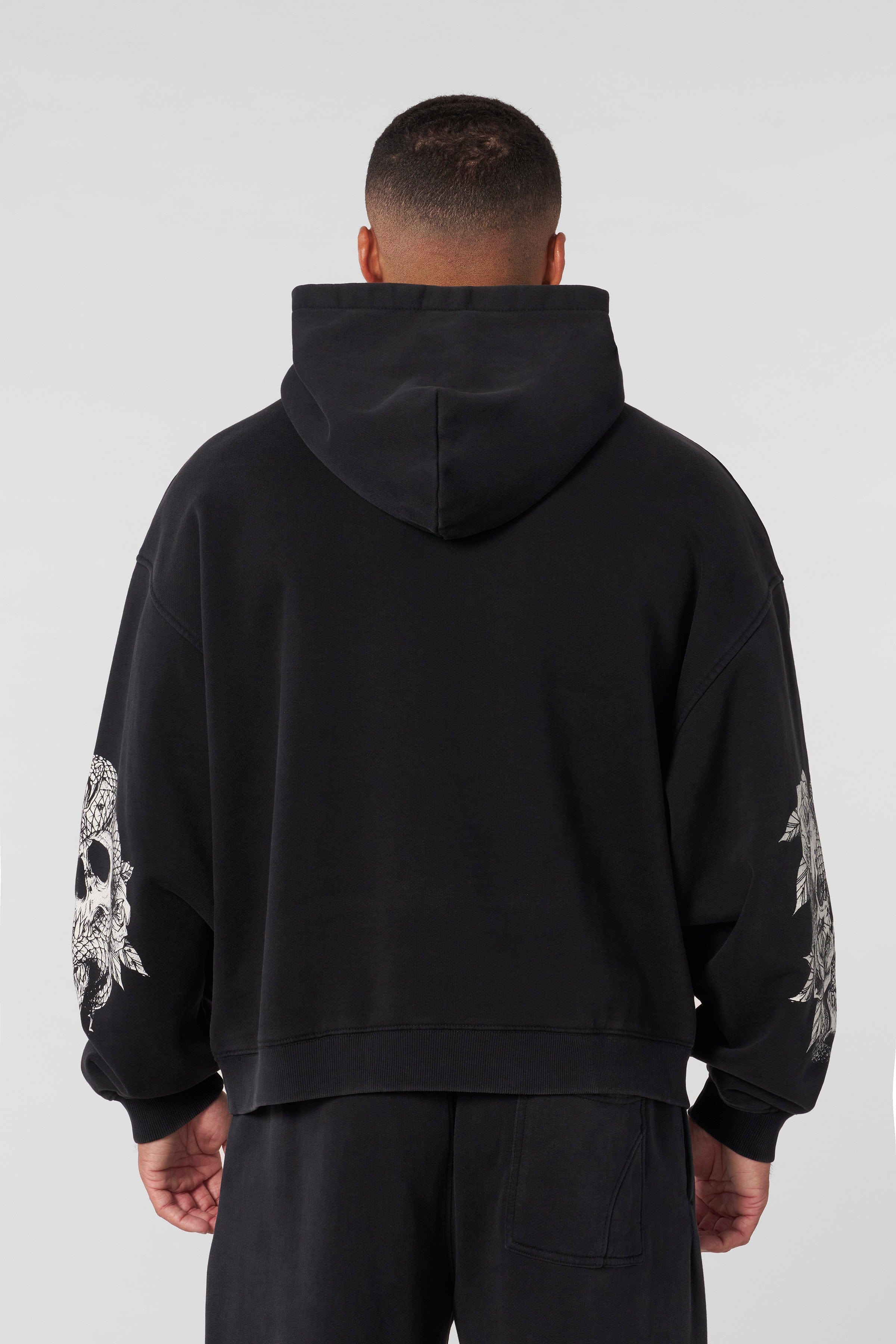 Side angle showing womens oversized hoodie fit and embroidered chest logo detail