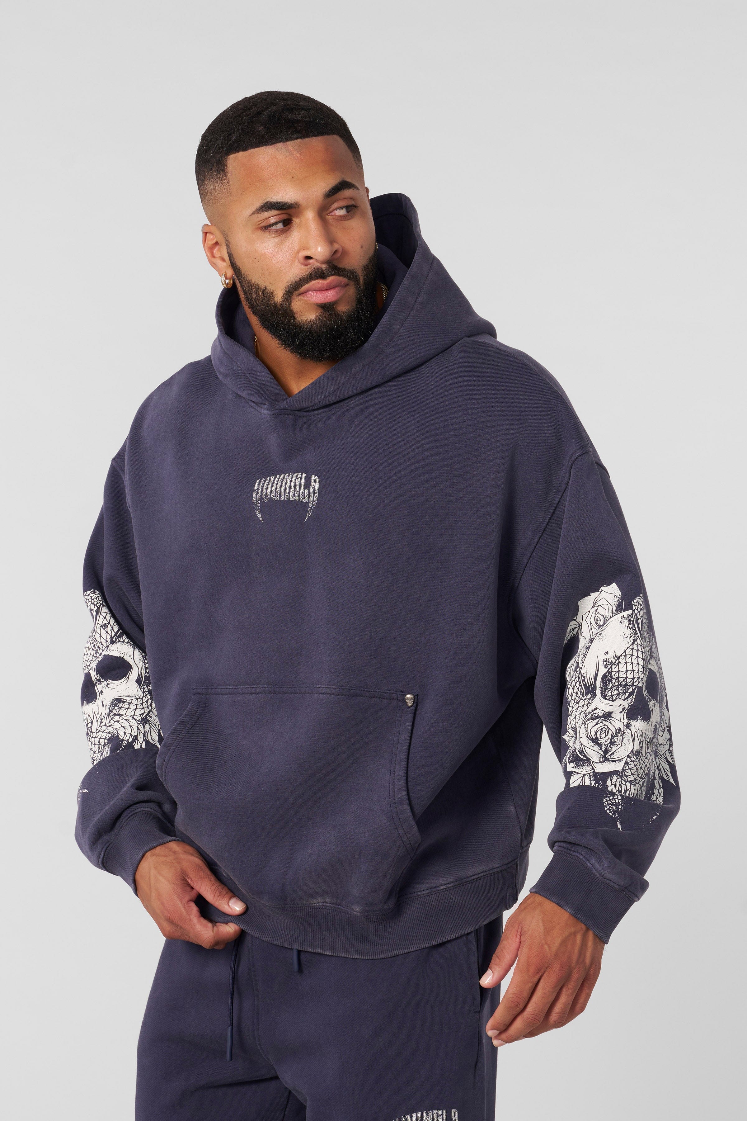 Side angle showing womens oversized hoodie fit and embroidered chest logo detail
