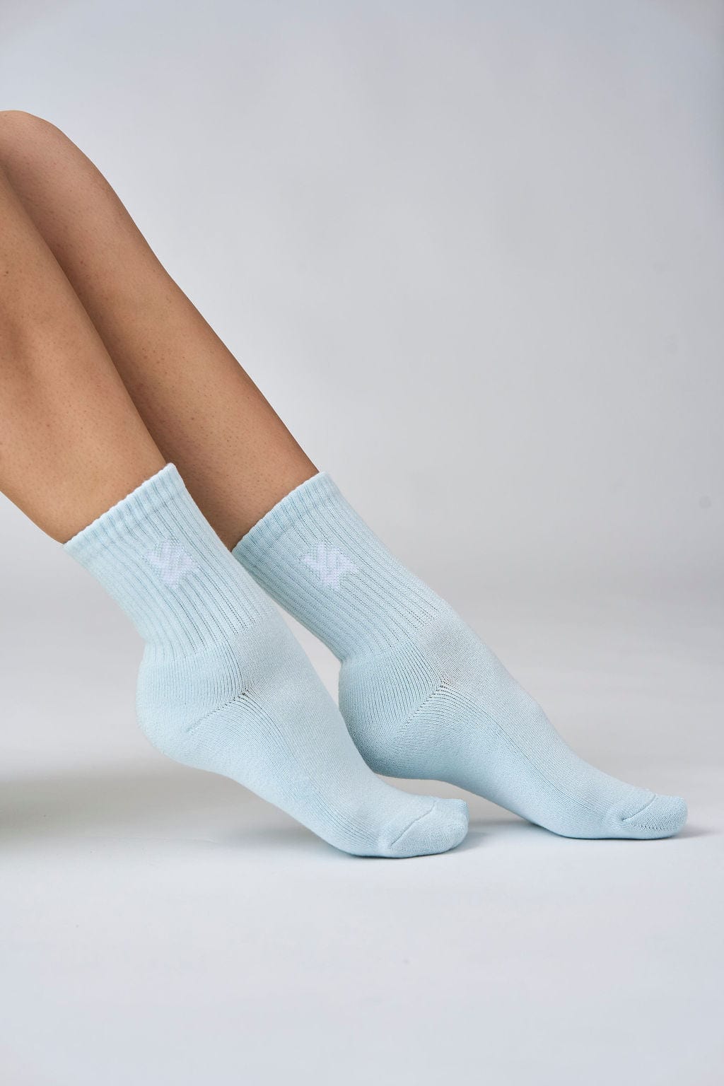 Model wearing comfortable cotton crew socks in casual setting.