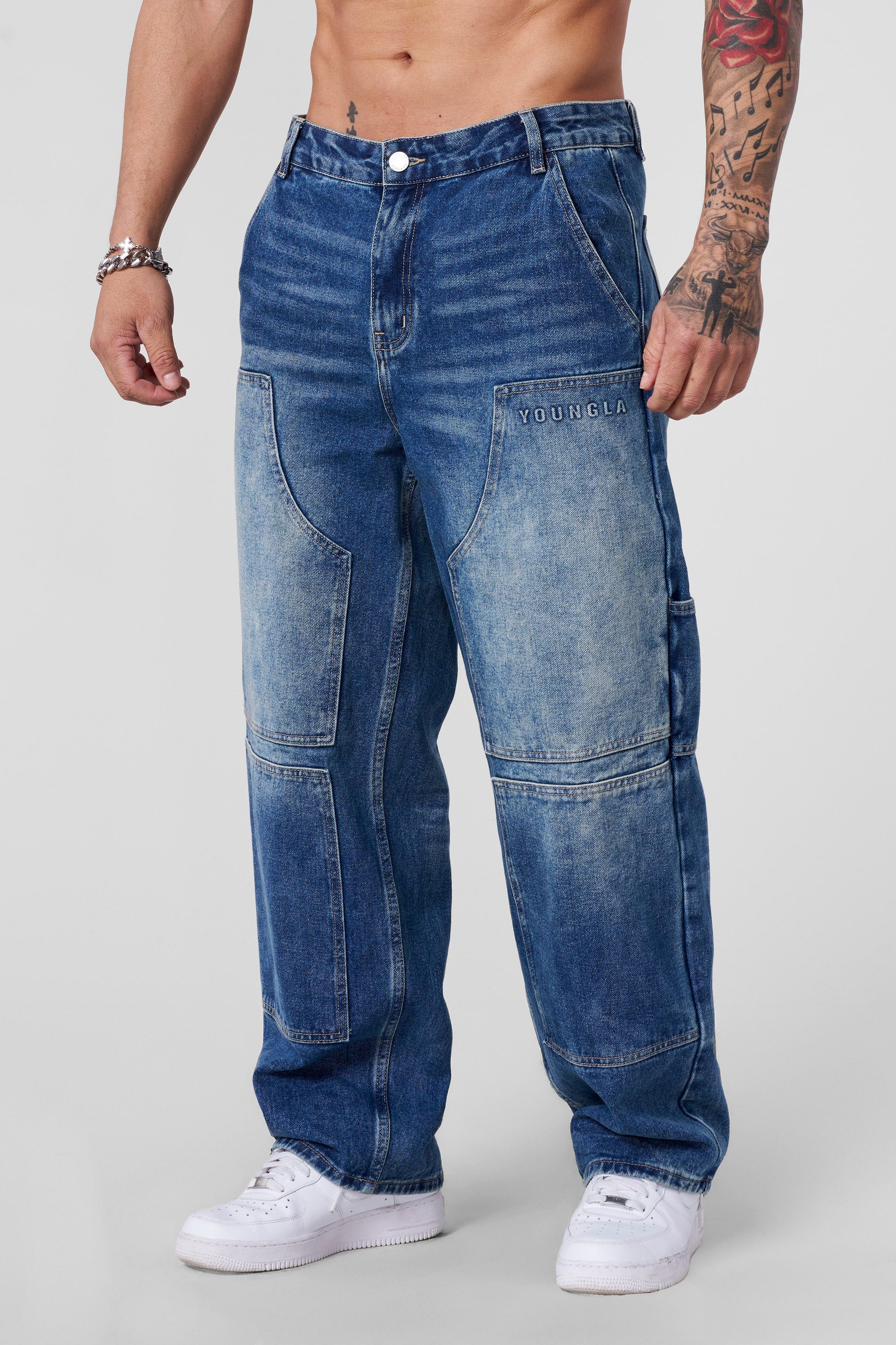 Close-up of baggy black jeans with reinforced stitching.