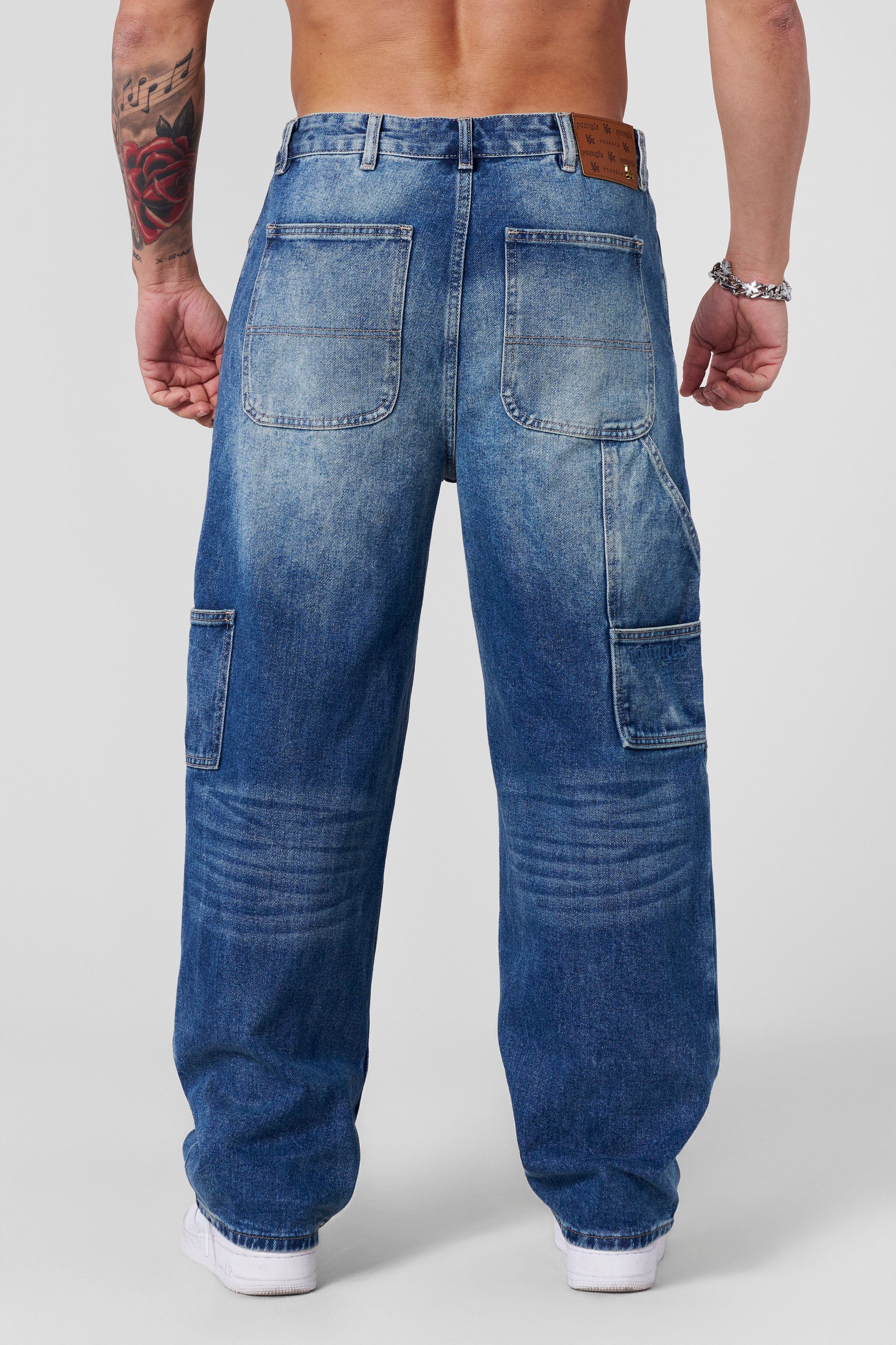 Model wearing low rise baggy jeans paired with sneakers.
