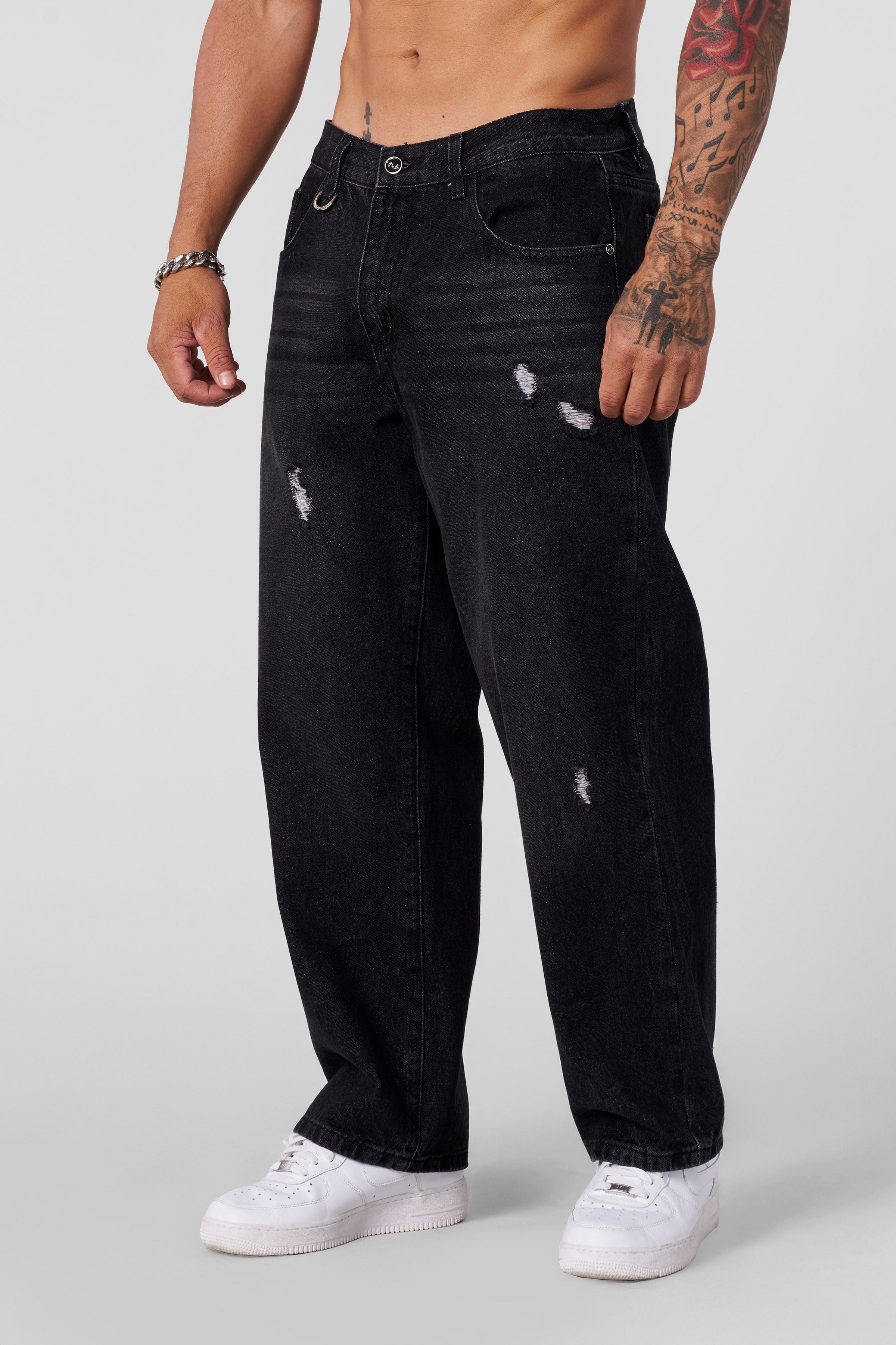 Close-up of distressed detailing on mens loose jeans
