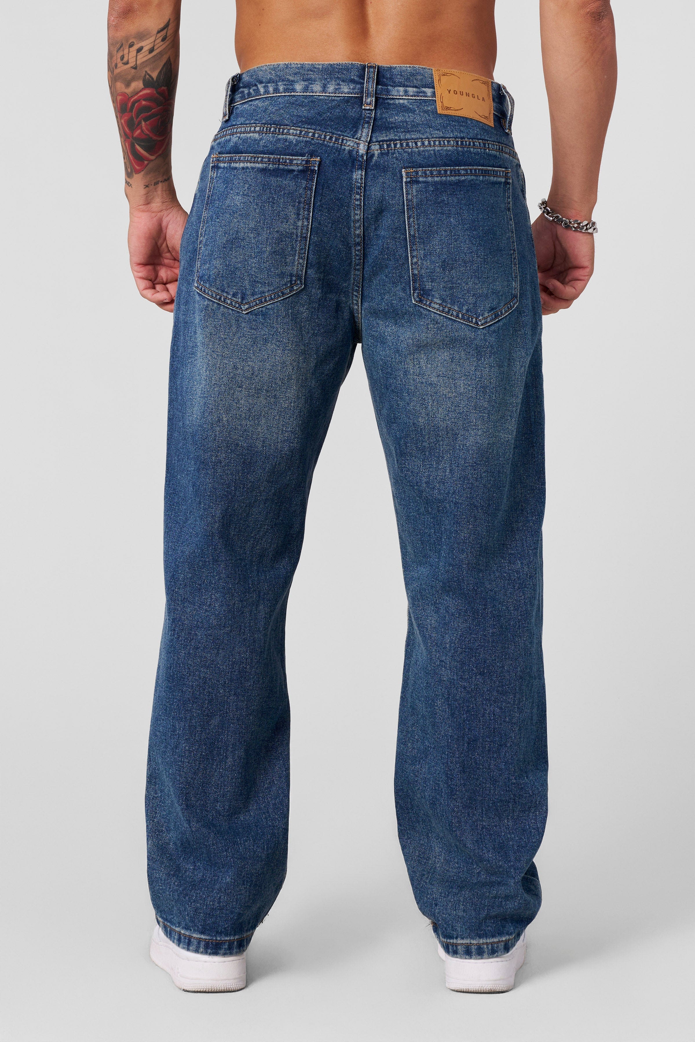 Back view of baggy black jeans, styled with sneakers