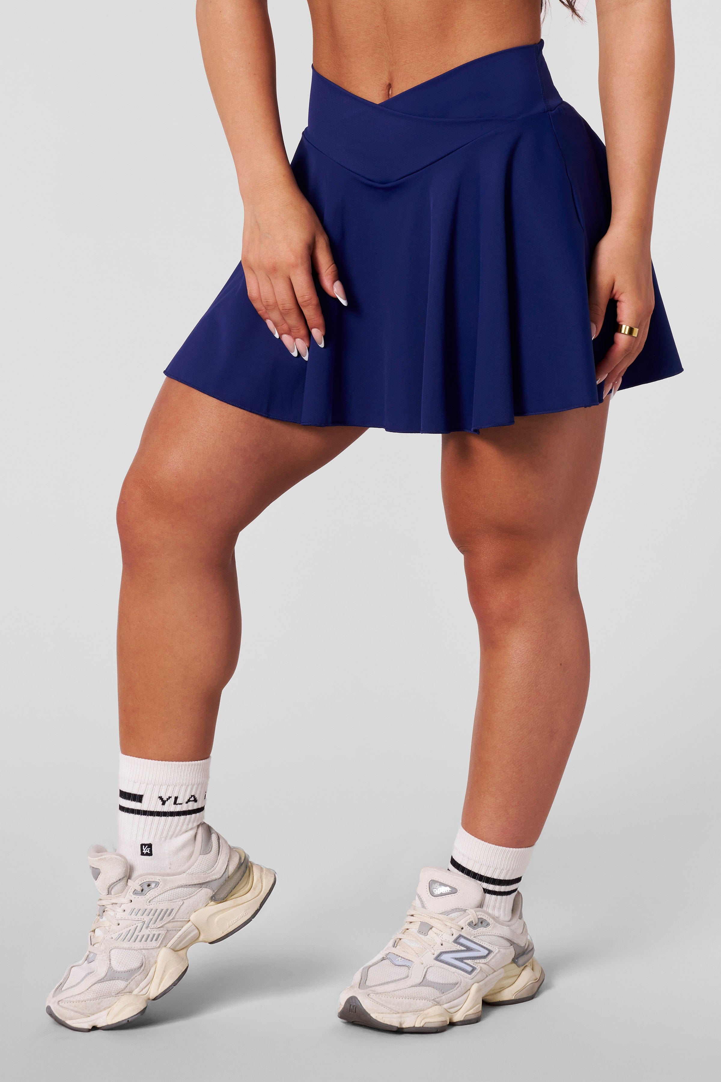 Model wearing the black tennis skirt on the court for activewear style