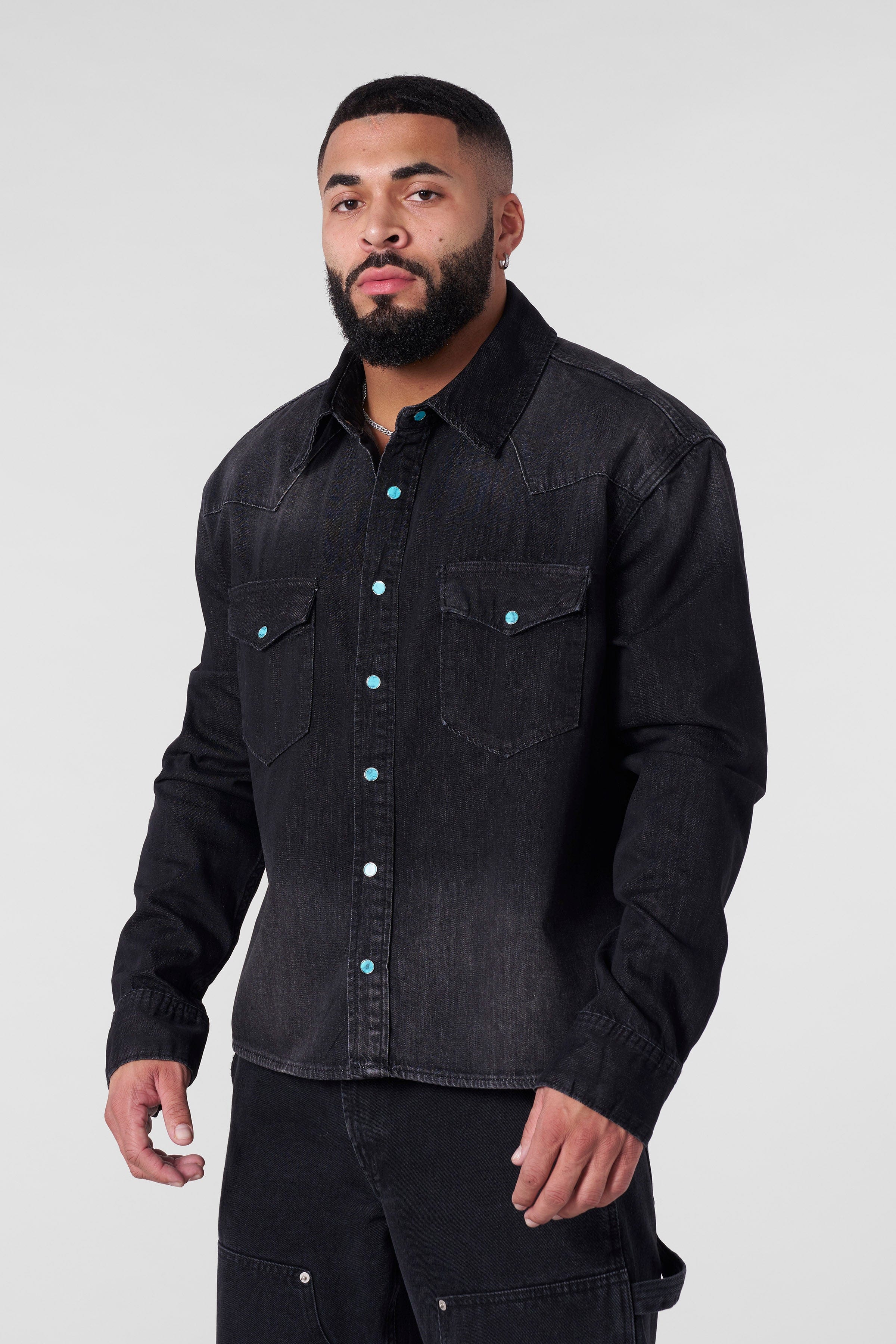 Close-up of the turquoise buttons on the denim shirt.