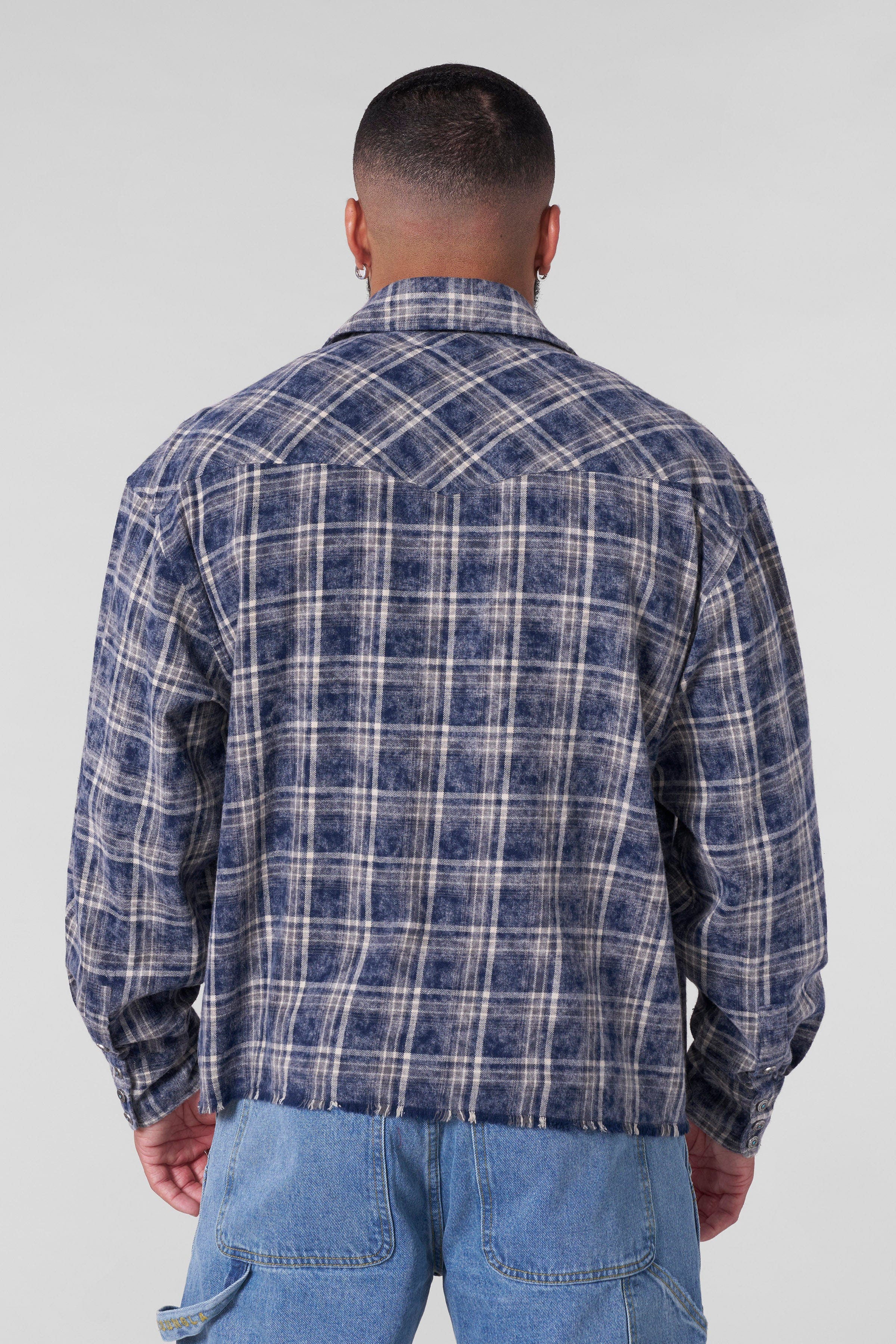 Urban Outlaw flannel shirt displayed on a hanger, highlighting its boxy fit design.