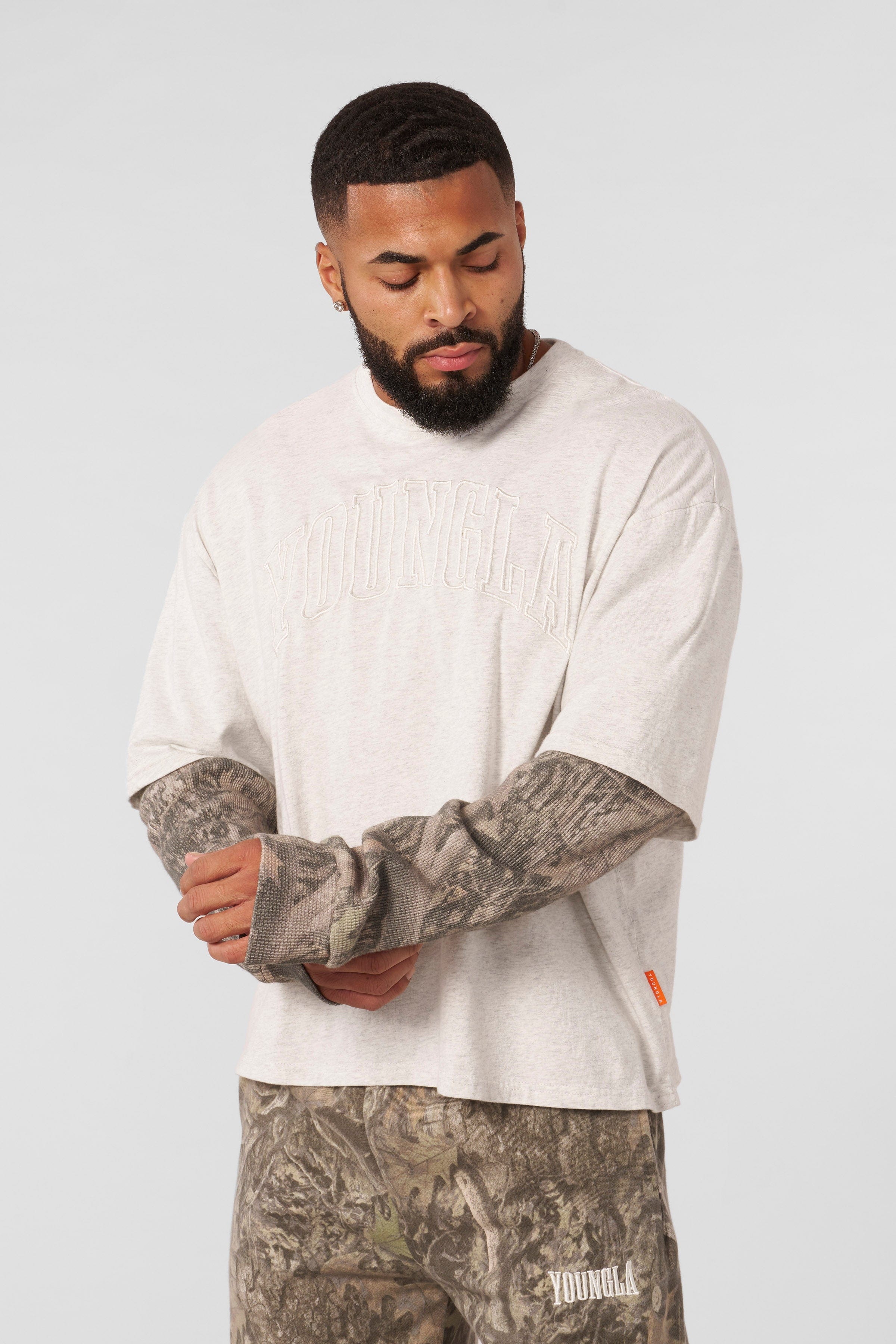 Model wearing the mens camo twofers in a natural outdoor setting.